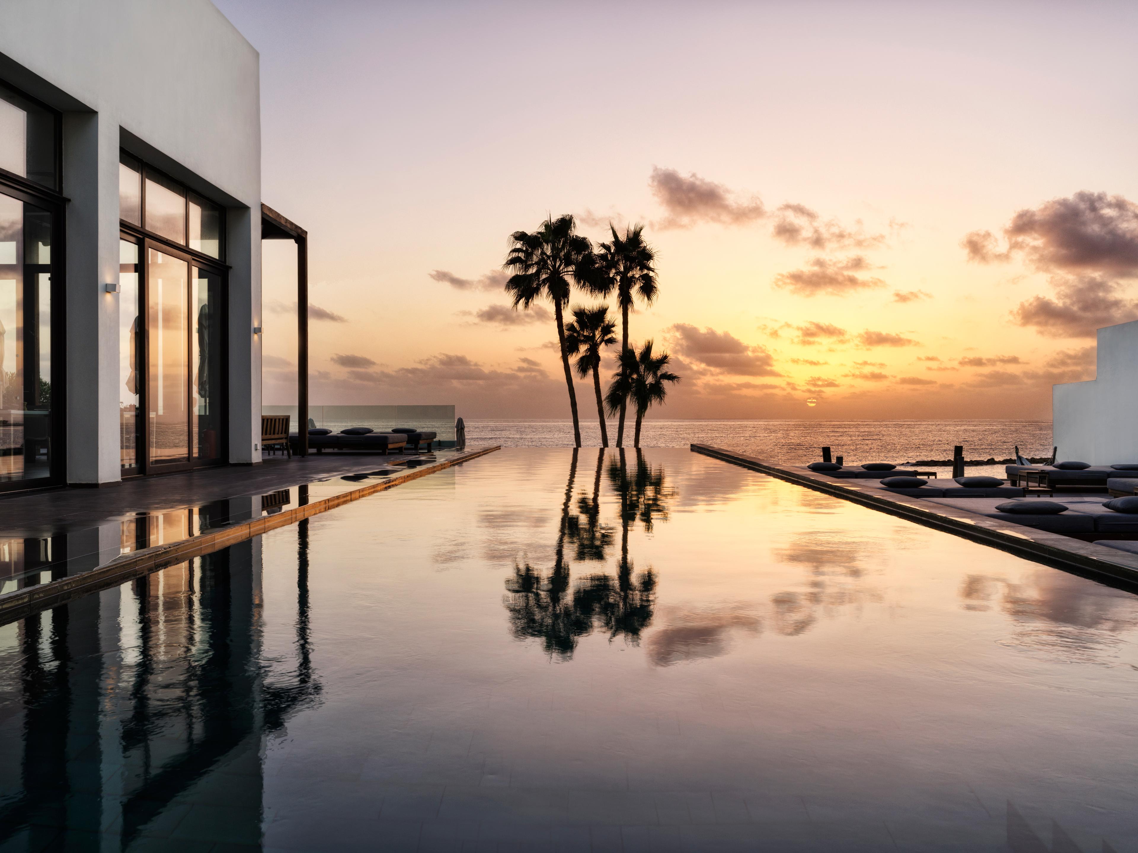 Sun setting over the infinity pool at Almyra Hotel
