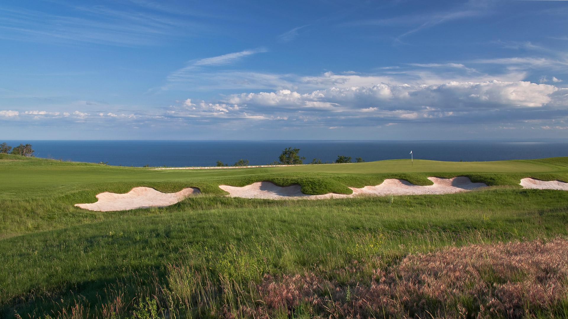 Panoramic view of a well maintained coastal fairway nestled with sand bunkers