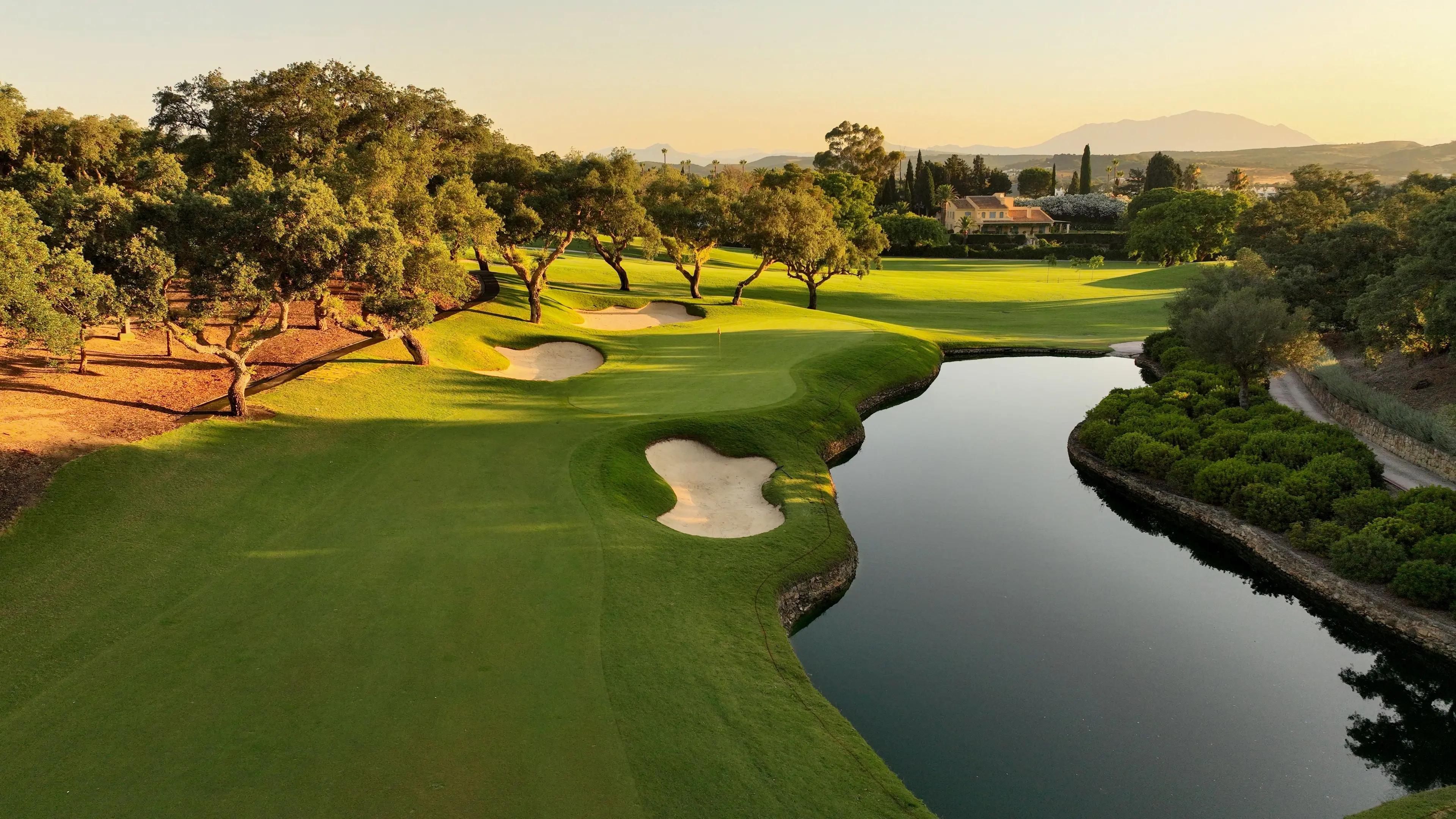 A well maintained fairway nestled with a sand bunker running next to a water hazard
