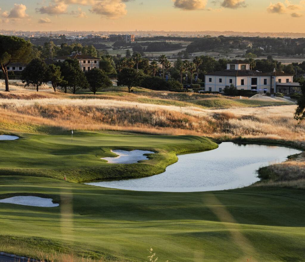 A well maintained fairway nestled with sand bunkers next to a water hazard