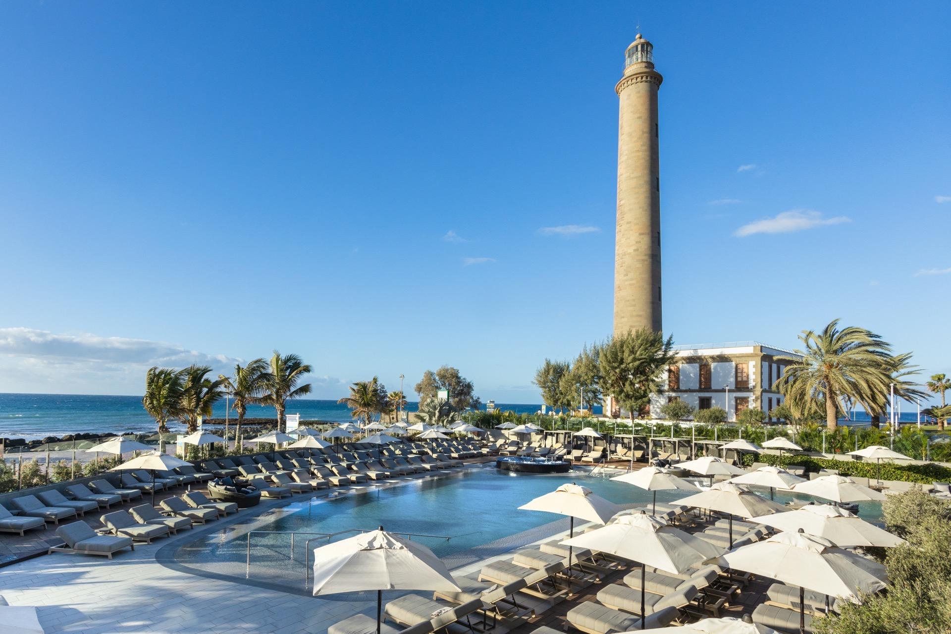 Outdoor pool area with a sea view and view of the lighthouse