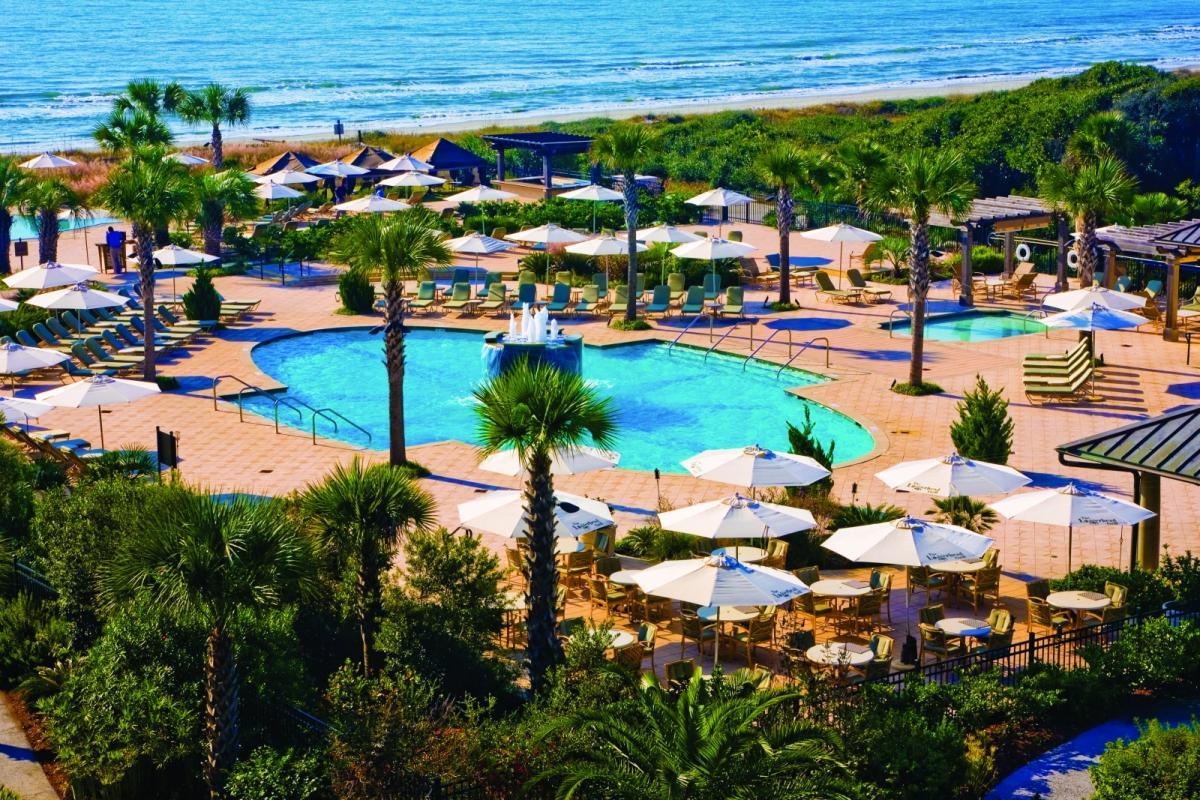 Outdoor swimming pool surrounded by sunbeds at Kiawah Island Golf Resort