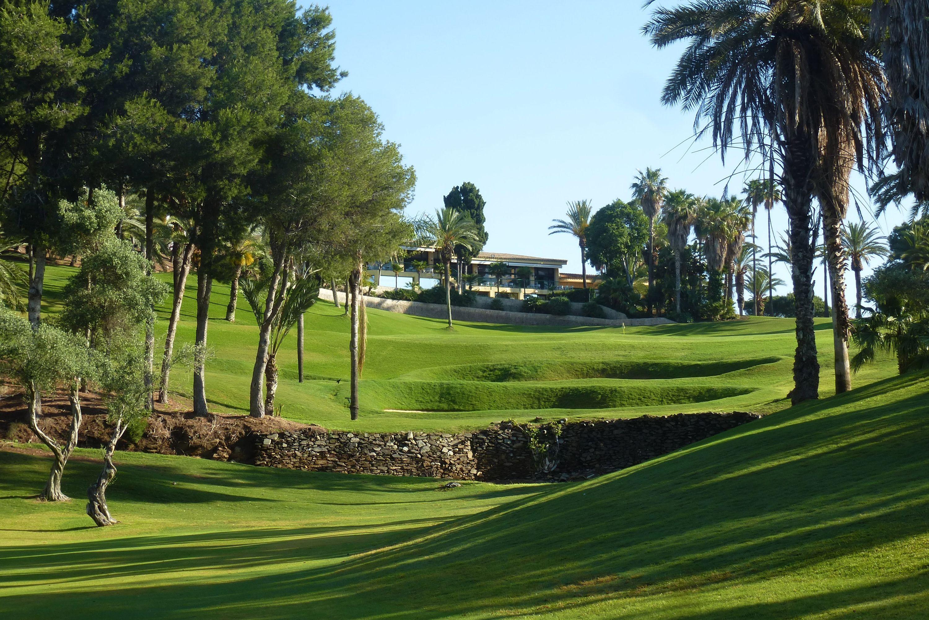 A well maintained fairway with the clubhouse in the distance