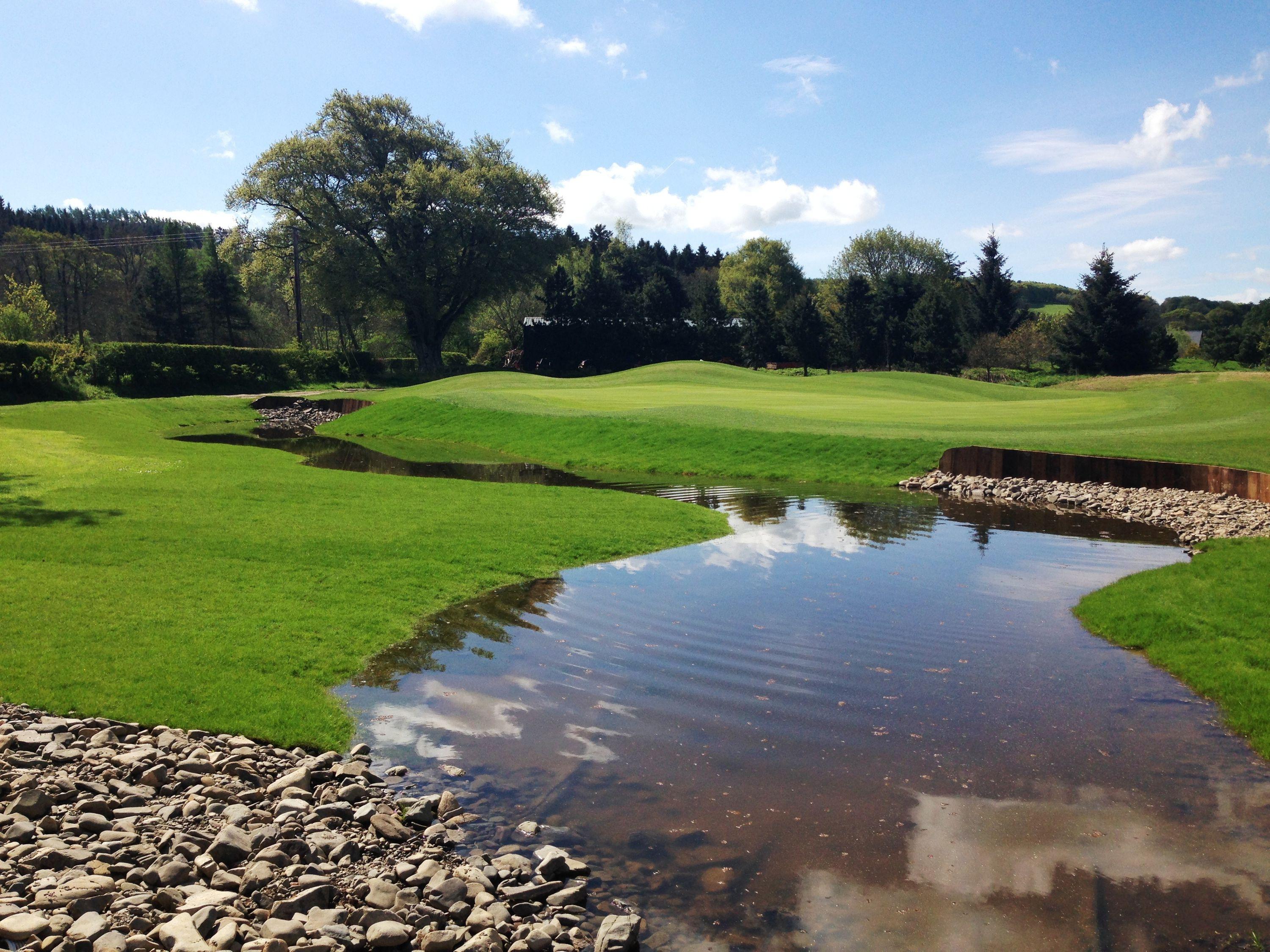A well maintained fairway running next to a water hazard