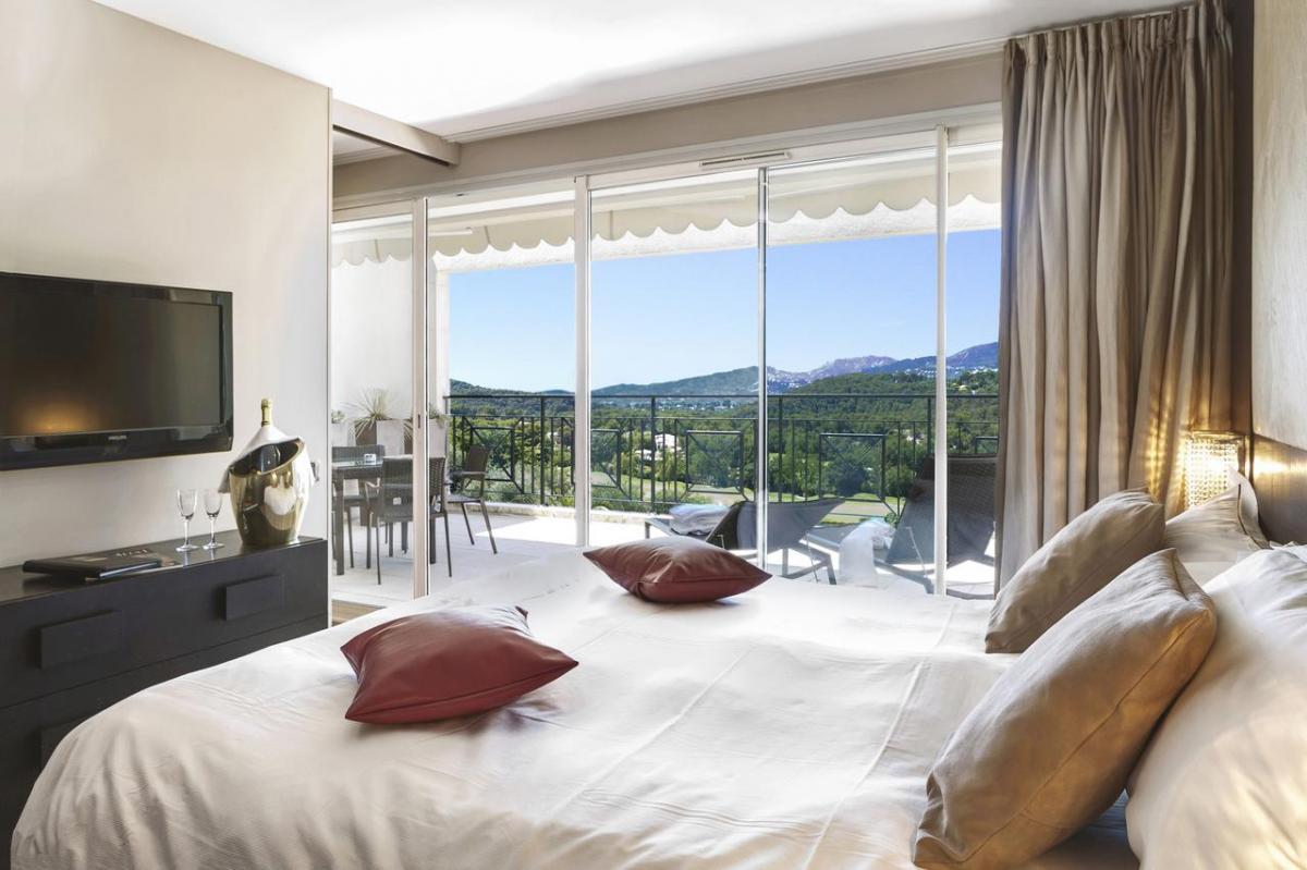 Double bed suite with balcony views of distant mountains at Royal Mougins Golf & Resort