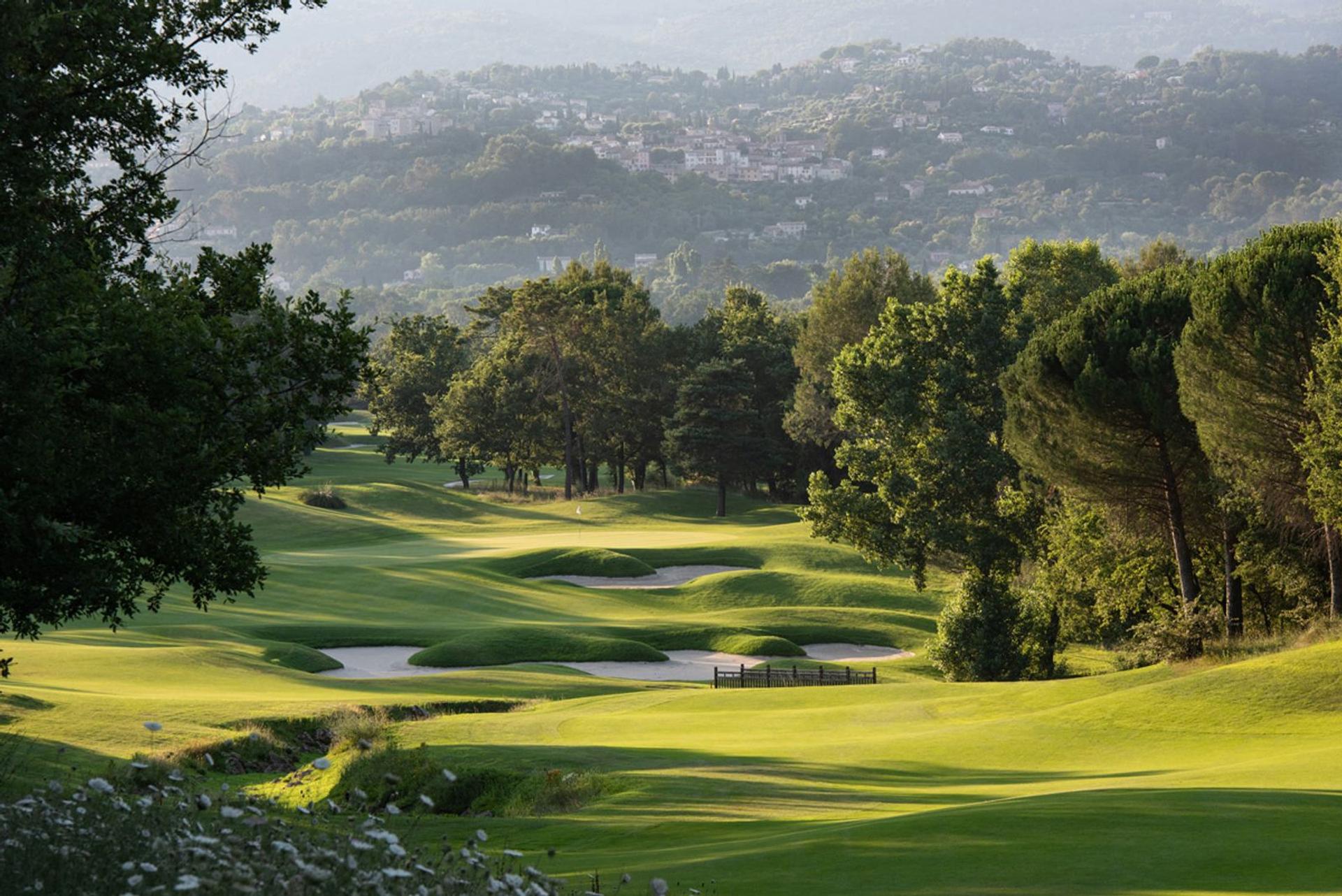 A well maintained downhill fairway nestled with sand bunkers