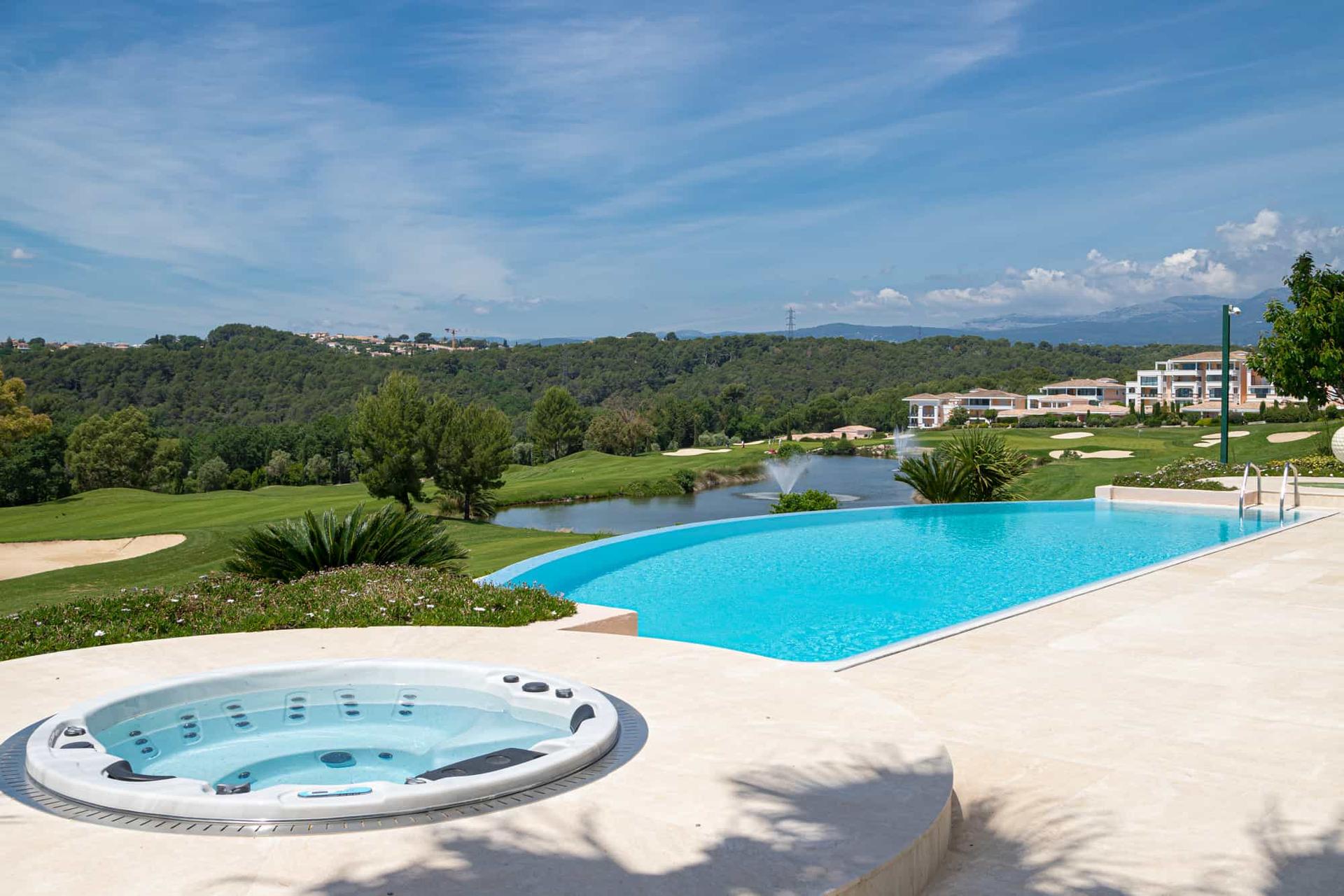 Outdoor swimming pool next to a jacuzzi with views of the course