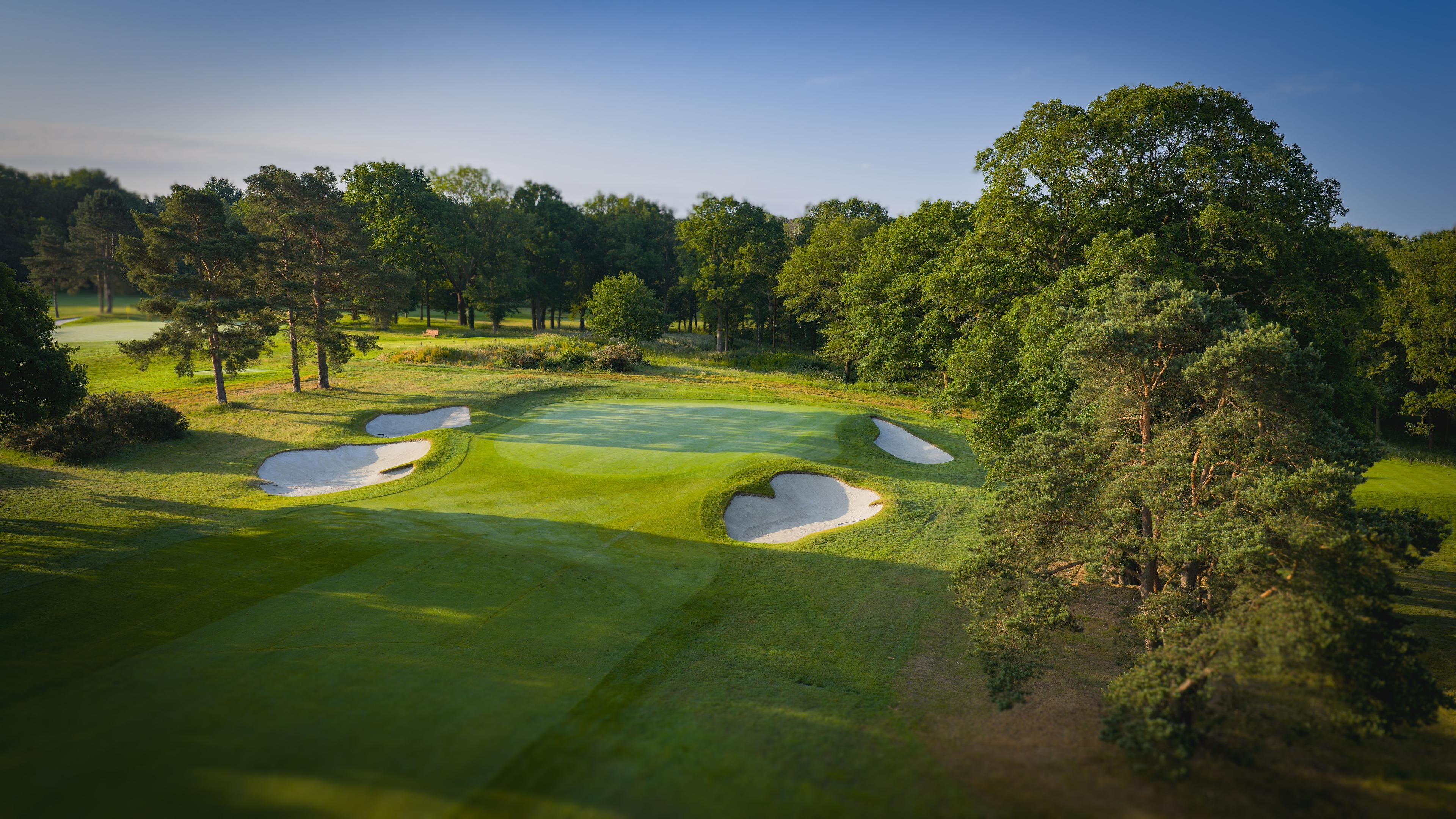 A well maintained fairway leading to smooth green surrounded by sand bunkers