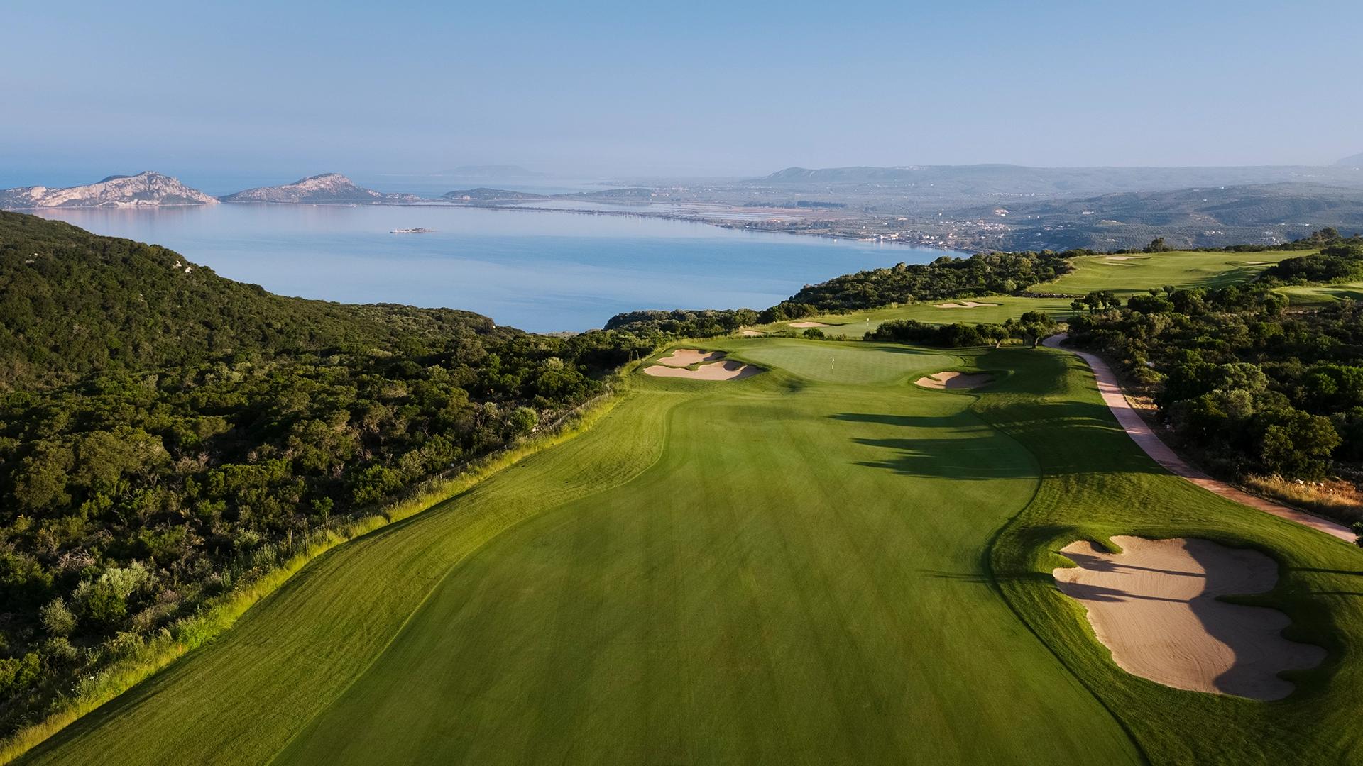 A well maintained fairway nestled with sand bunkers with coastal views