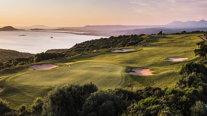 A well maintained fairway nestled with sand bunkers leading to a smooth green