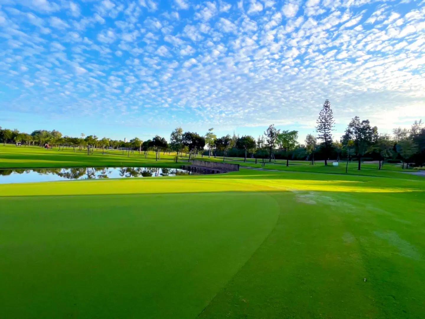 A well maintained fairway next to a water hazard