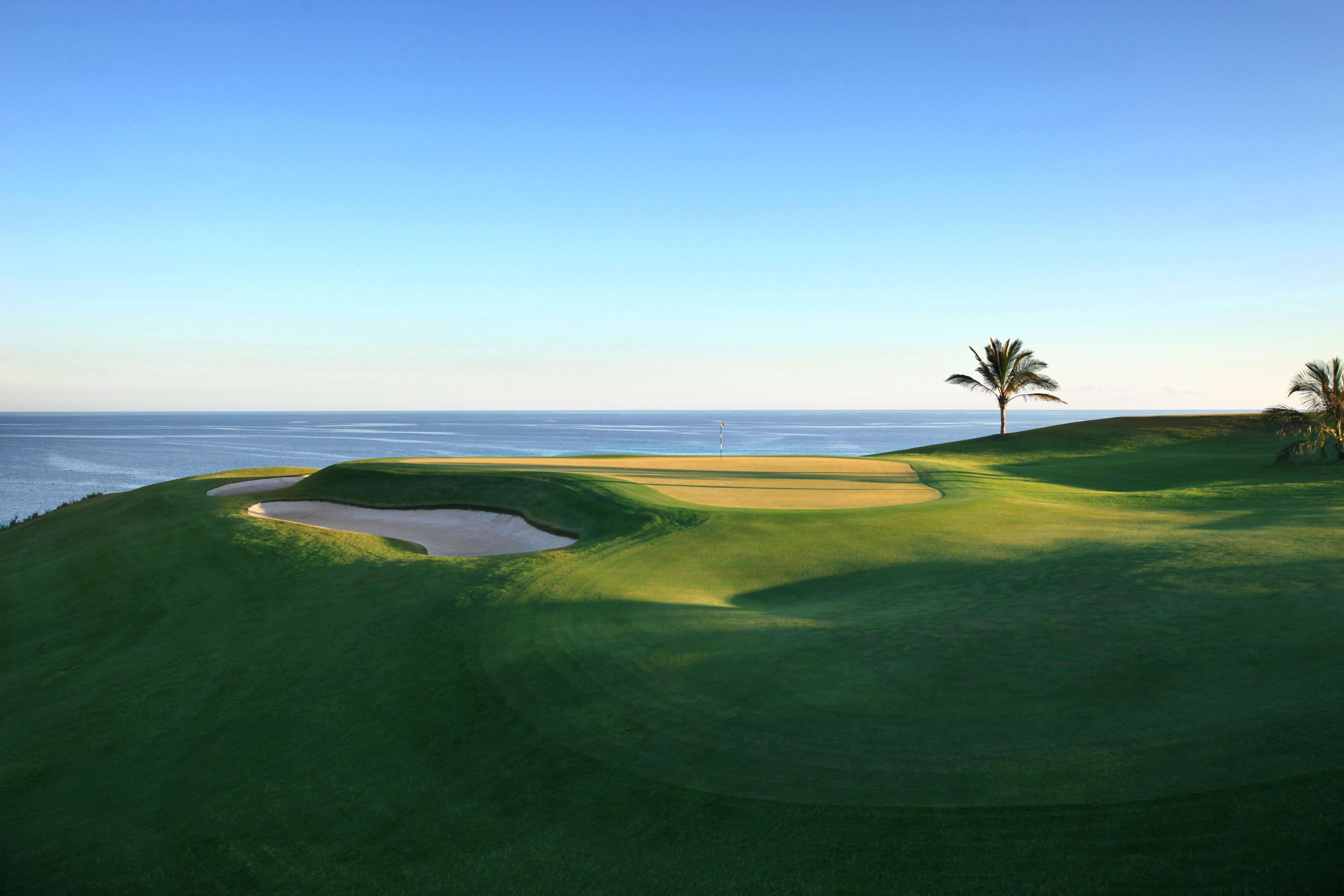 A coastal green next to a sand bunker