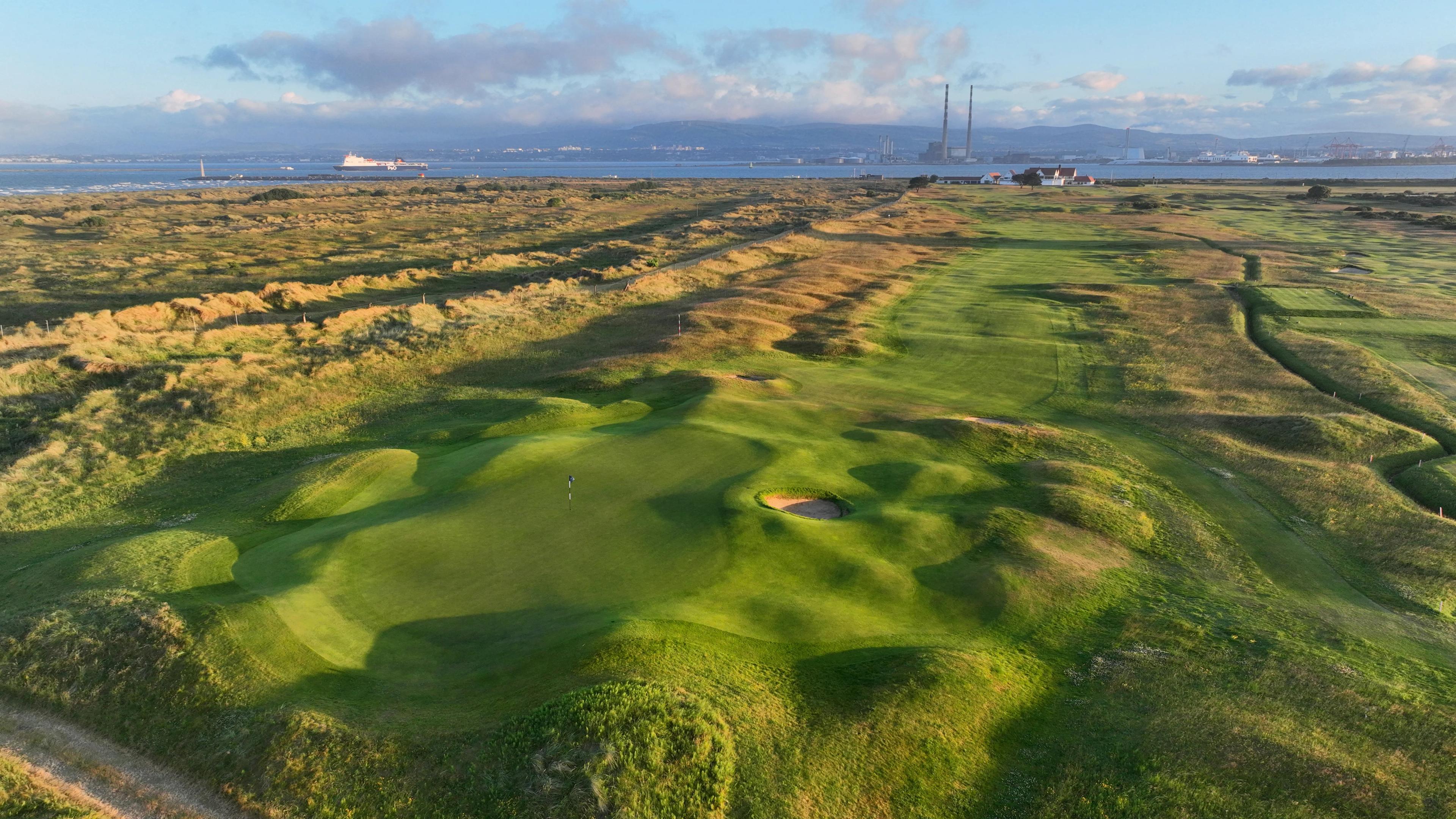 a bumpy golf green surrounded by tall grass