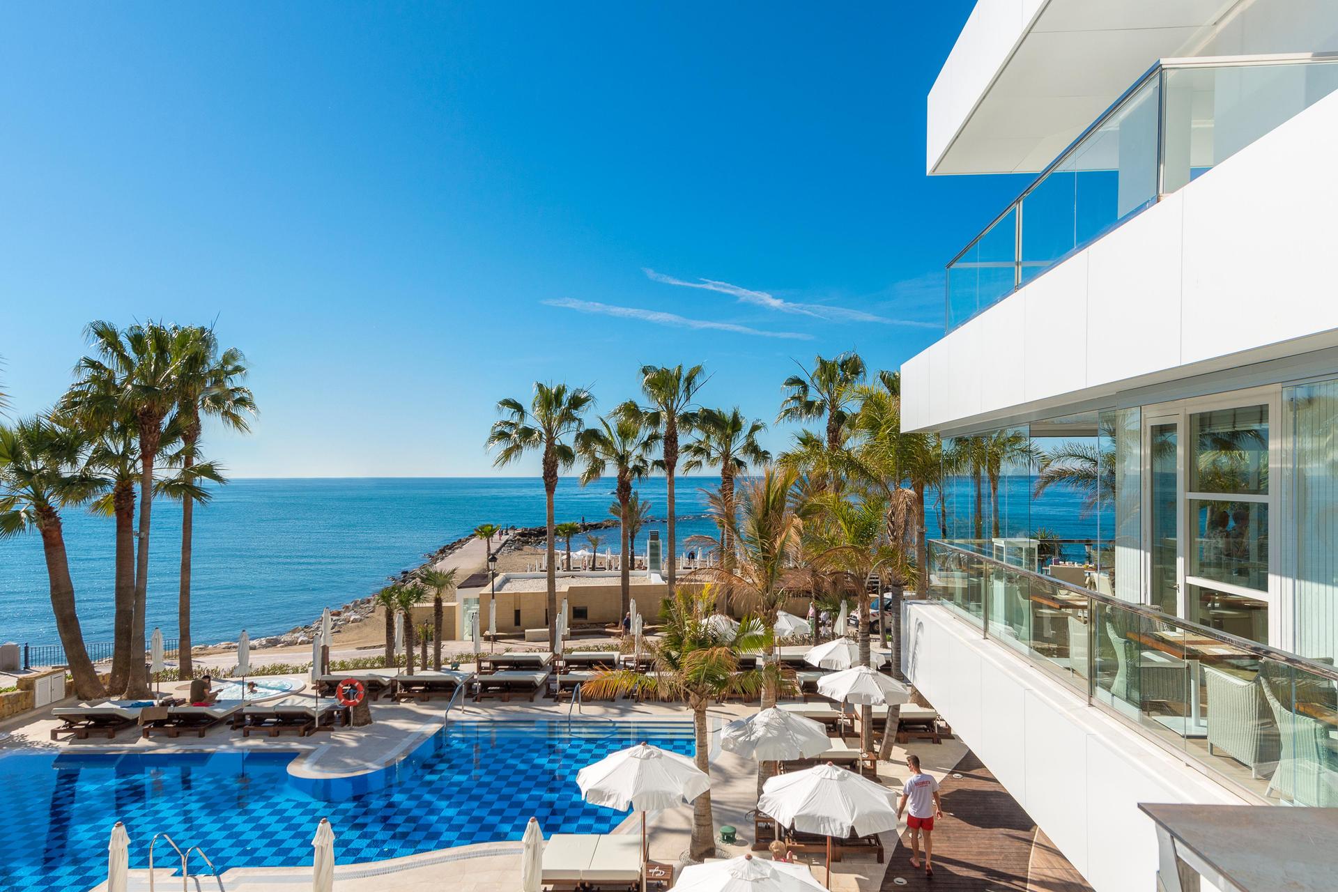 Balcony views of the outdoor pool and coast at Amàre Beach Hotel Marbella