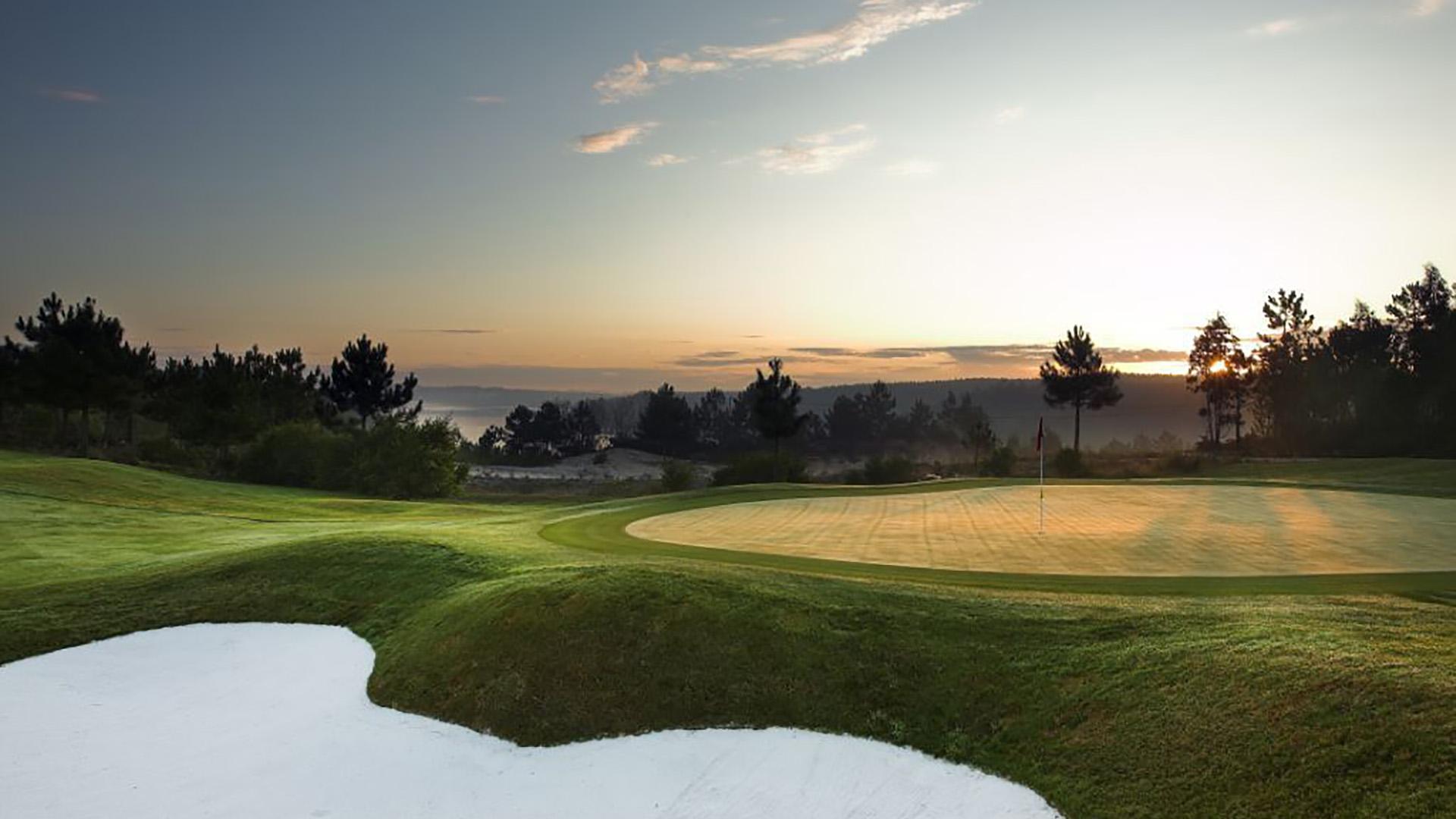 A smooth green next to a large sand bunker at Bom Sucesso Resort
