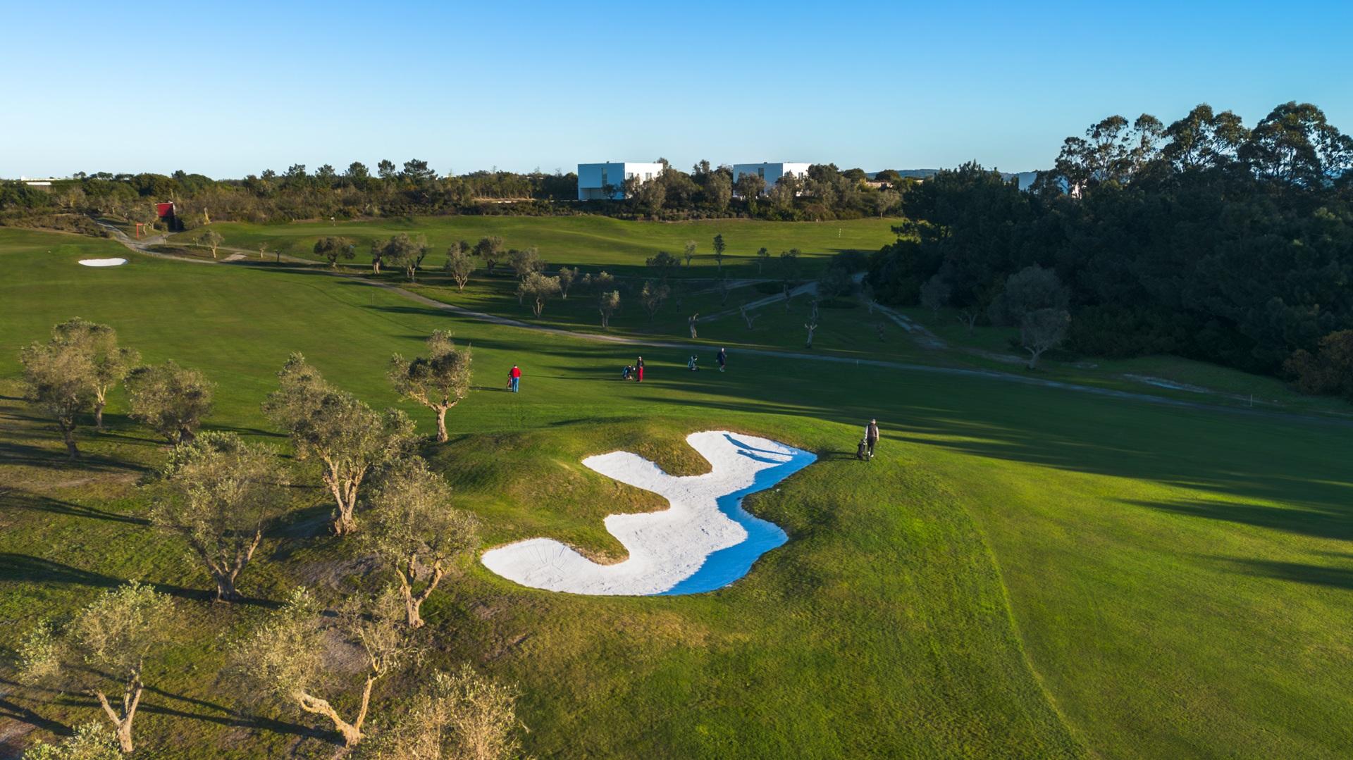 Overhead view of a well maintained fairway nestled with a large sand bunker