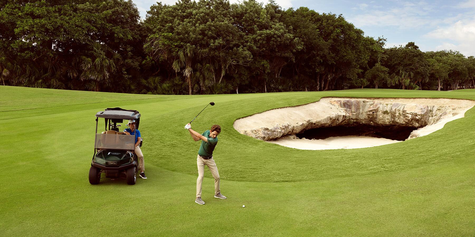 Golfer preparing wing on a well maintained fairway with a deep sand bunker