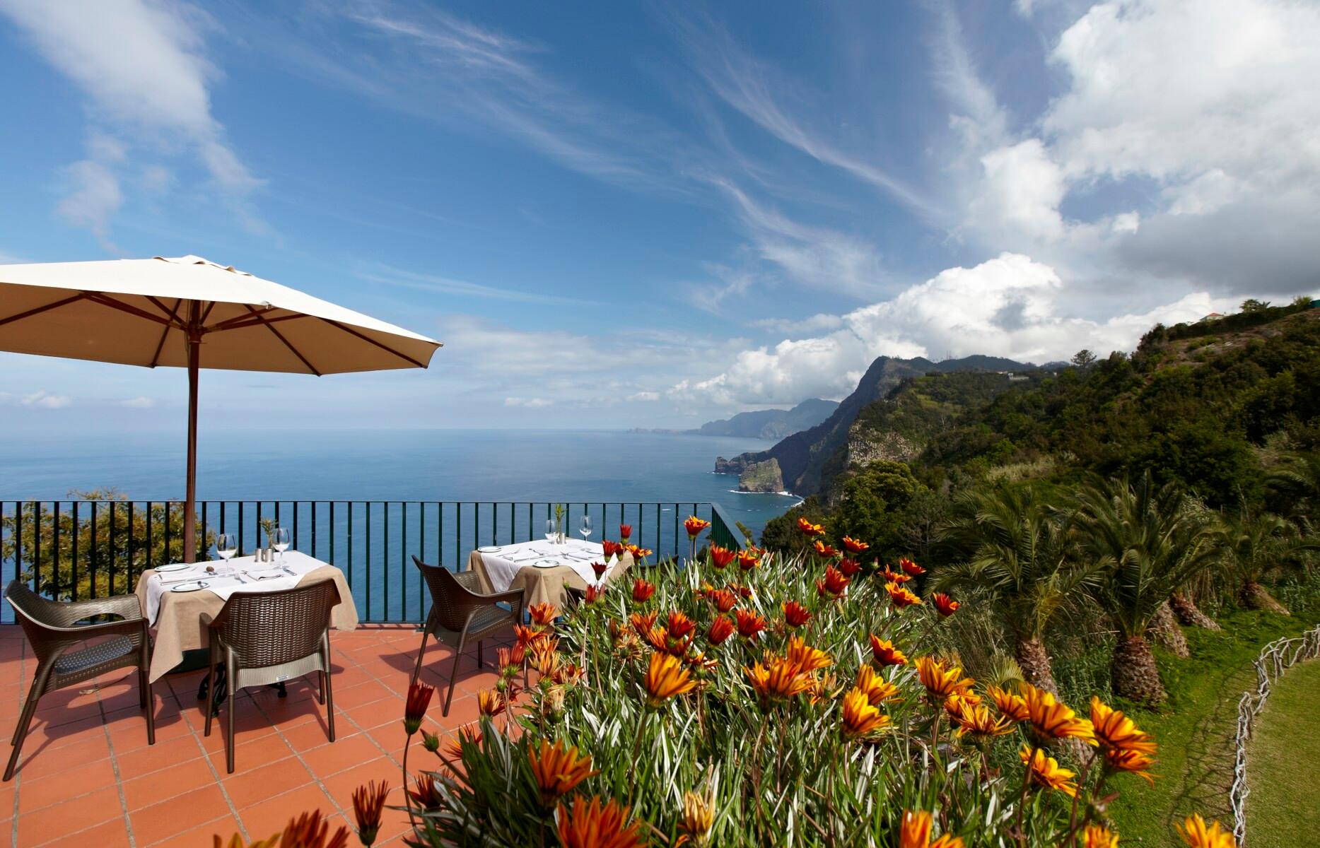 Outdoor cliff edge dining with ocean views at Hotel Quinta do Furão