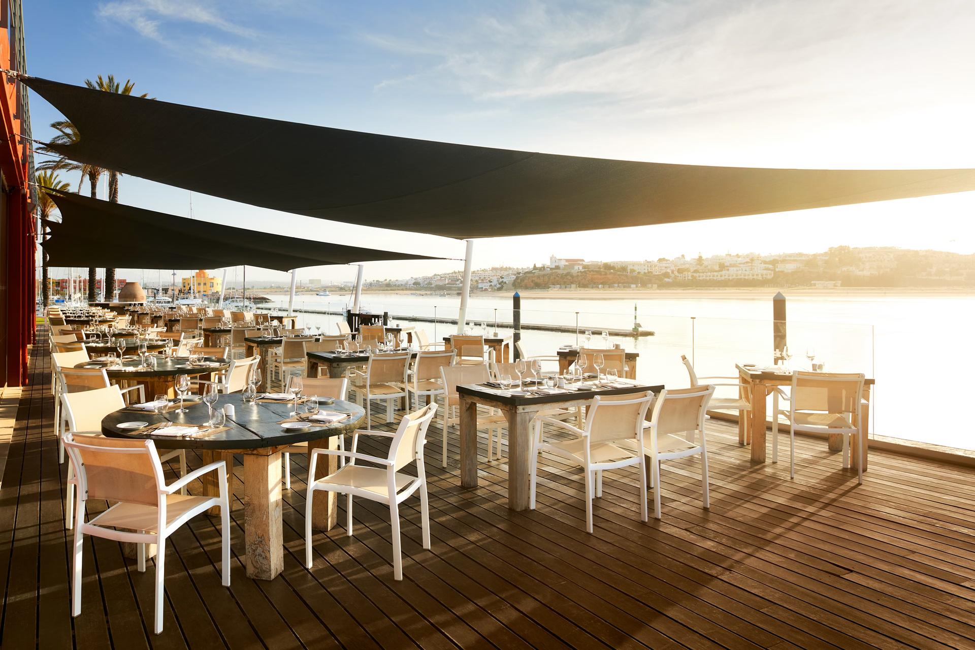 Outdoor dining area with sea views at NH Marina Portimão