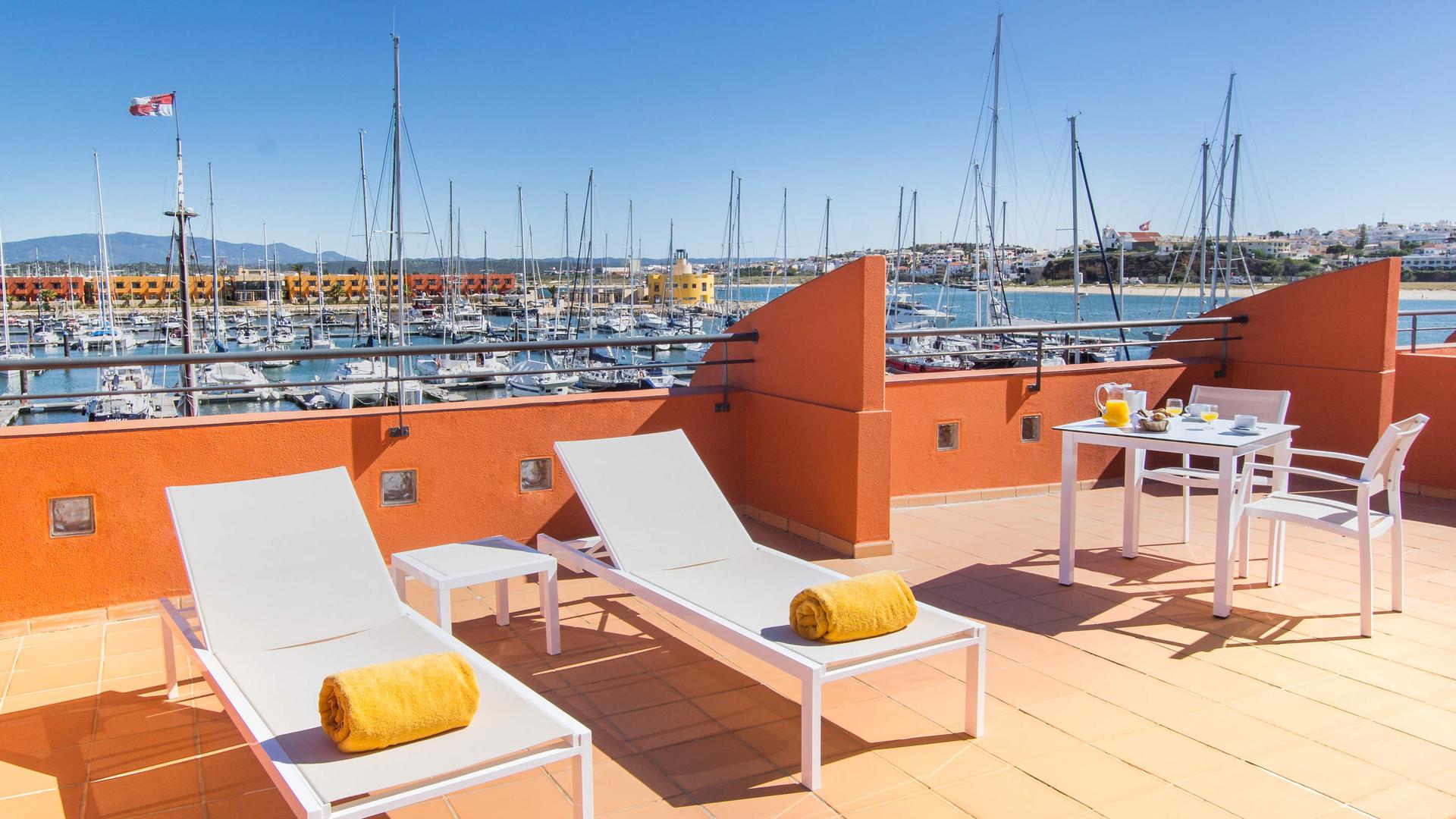 Rooftop lounging area nestled with sunbeds at NH Marina Portimão