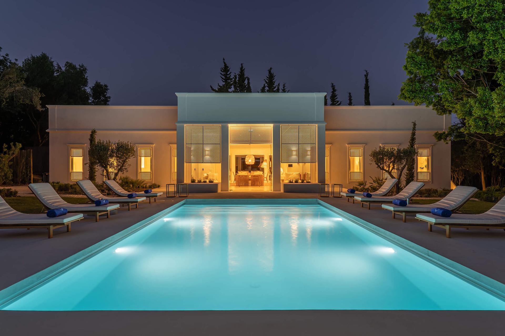 Outdoor swimming pool at Octant Hotel Vila Monte lit up at evening time