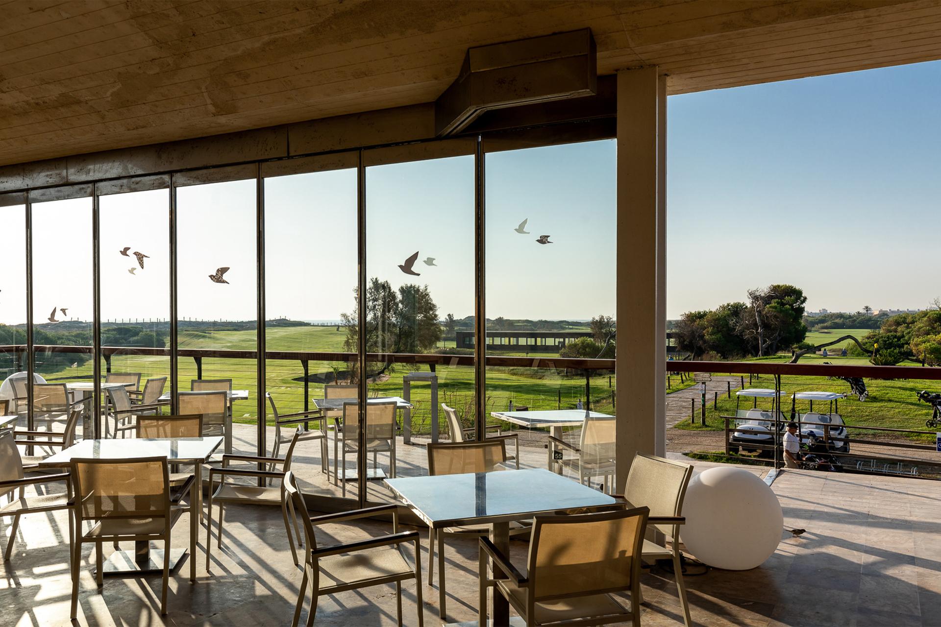 Indoor dining area with views of the course at Parador El Saler