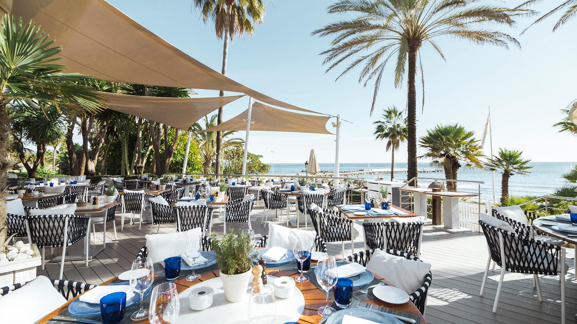 Outdoor dining area with sea views at Puente Romano Beach Resort