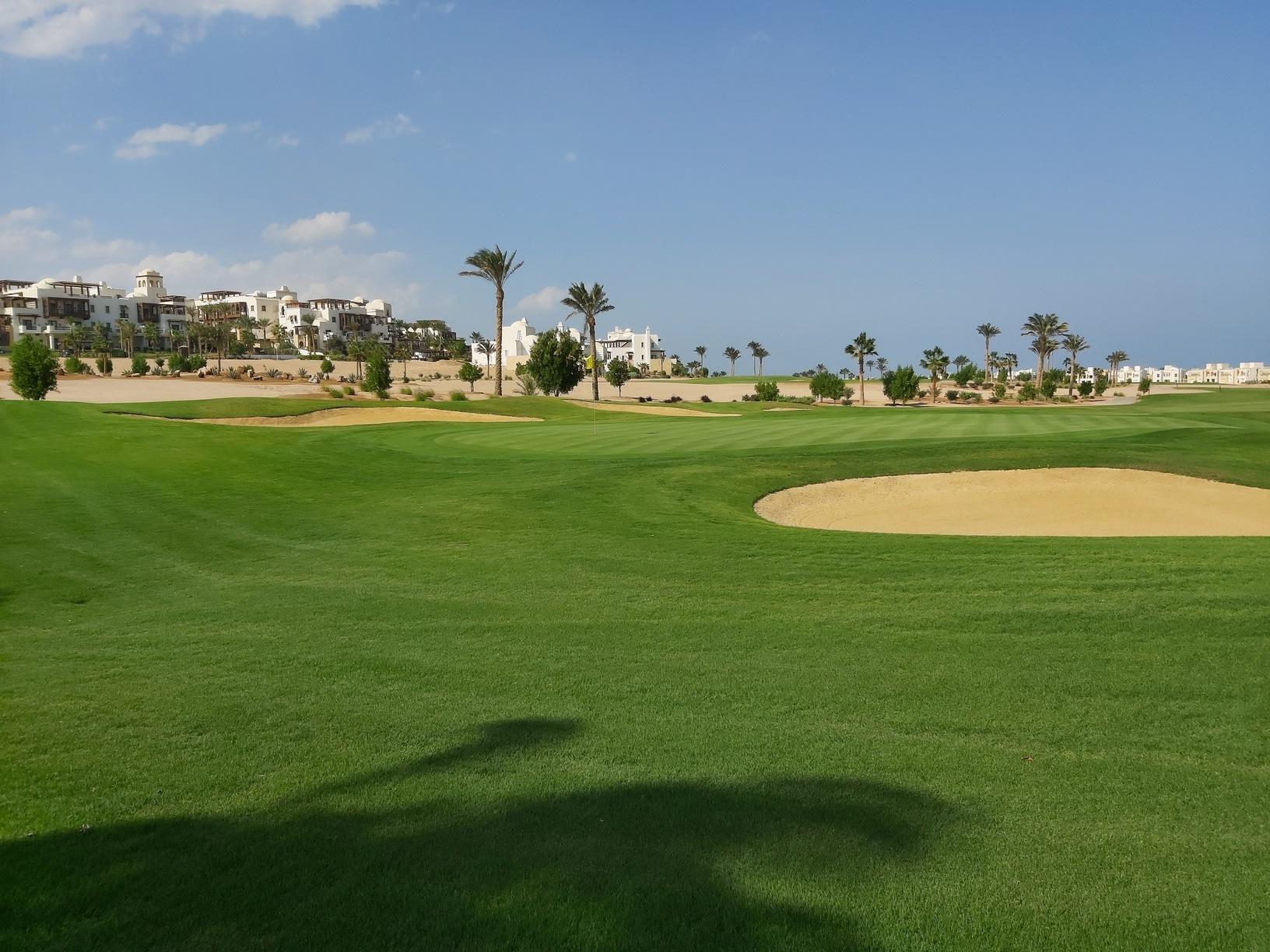 A well maintained fairway nestled with a sand bunker