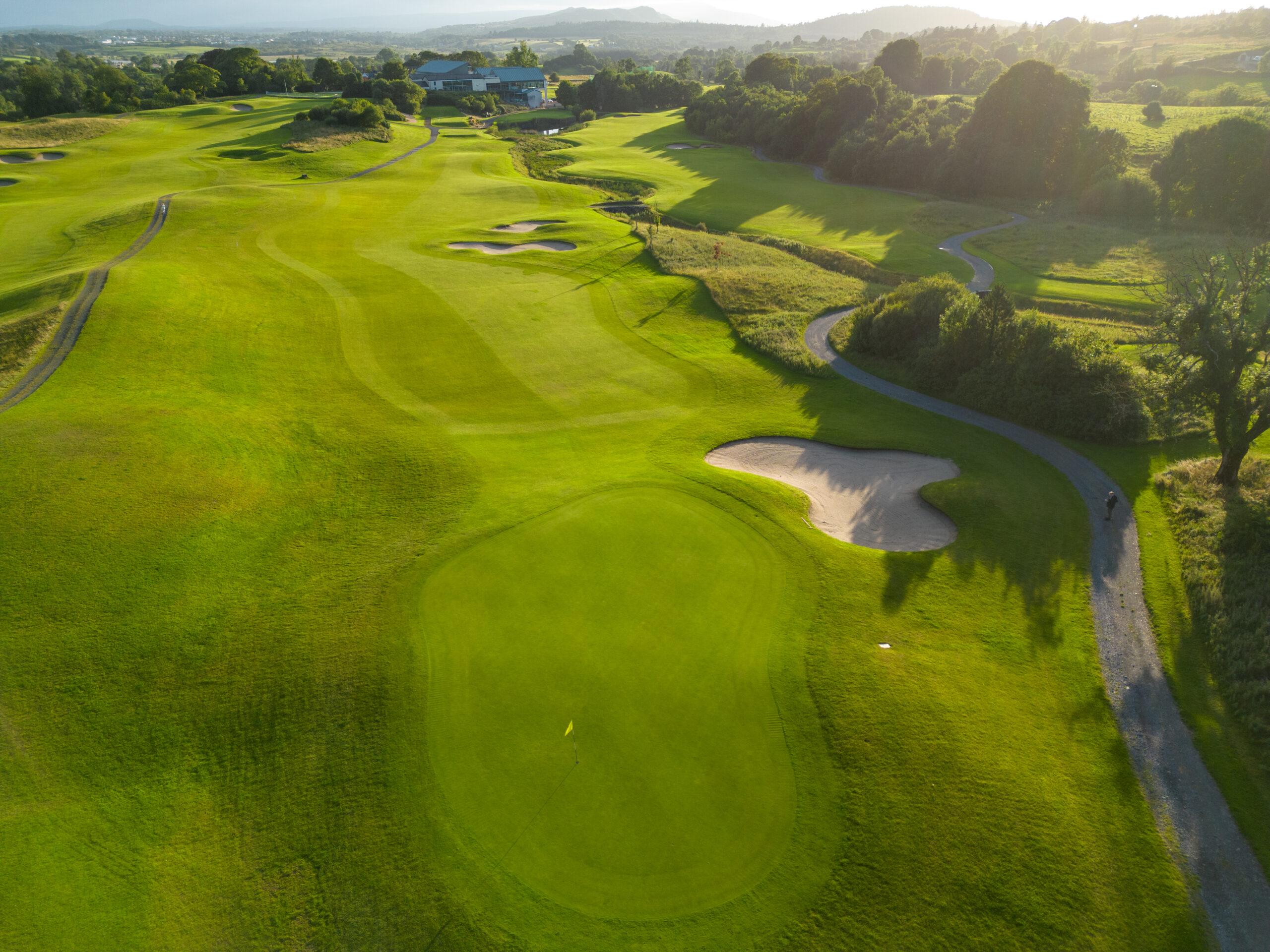 A well maintained fairway leading to a smooth green next to a sand bunker