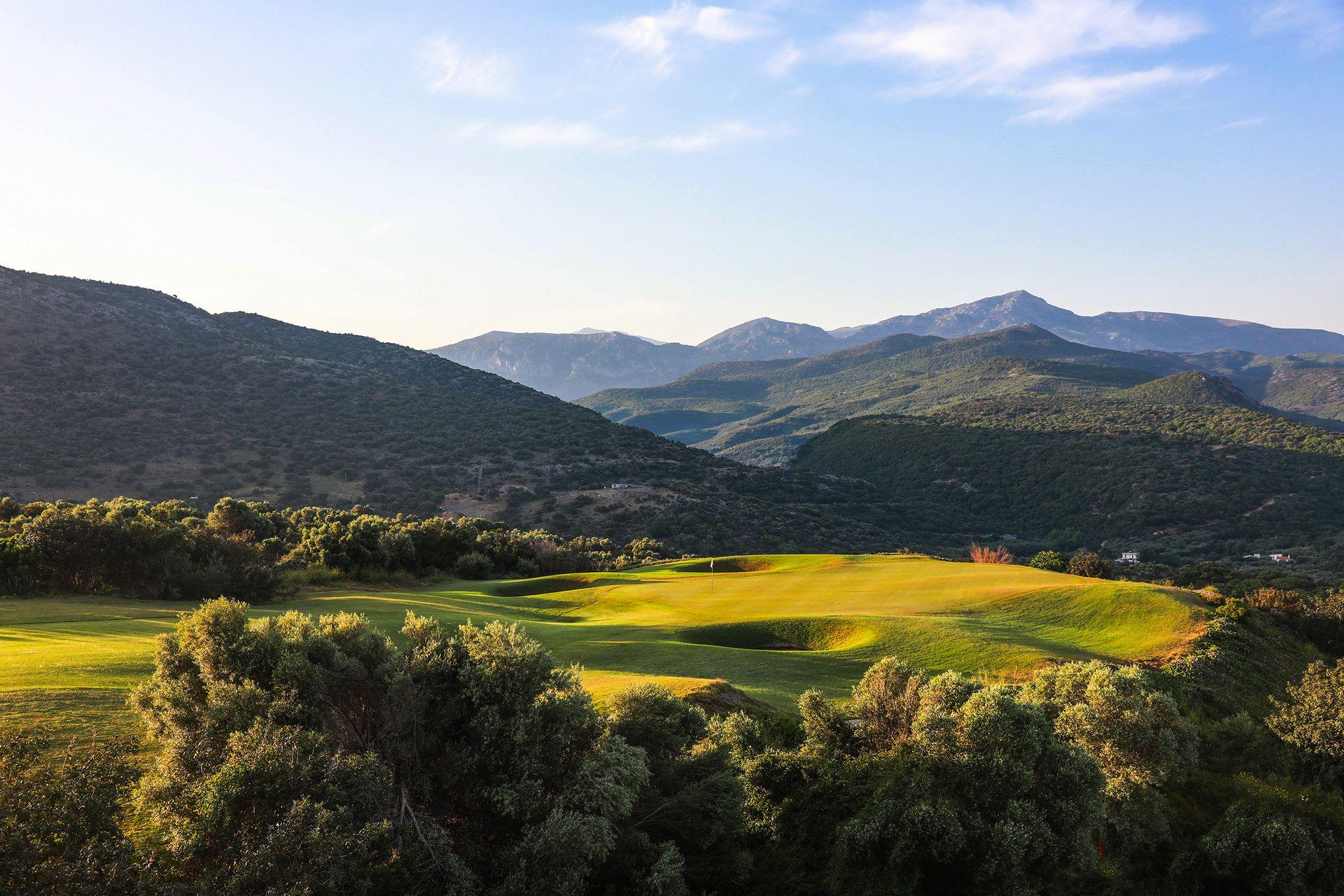 A well maintained fairway leading to a smooth elevated green at Crete Golf Club & Hotel