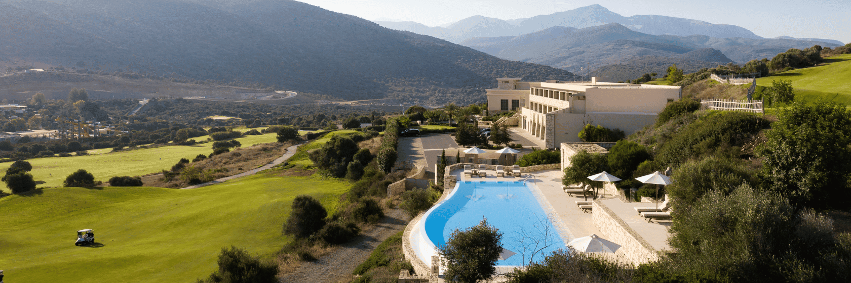Overhead view of the outdoor swimming pool overlooking the golf course at Crete Golf Club & Hotel