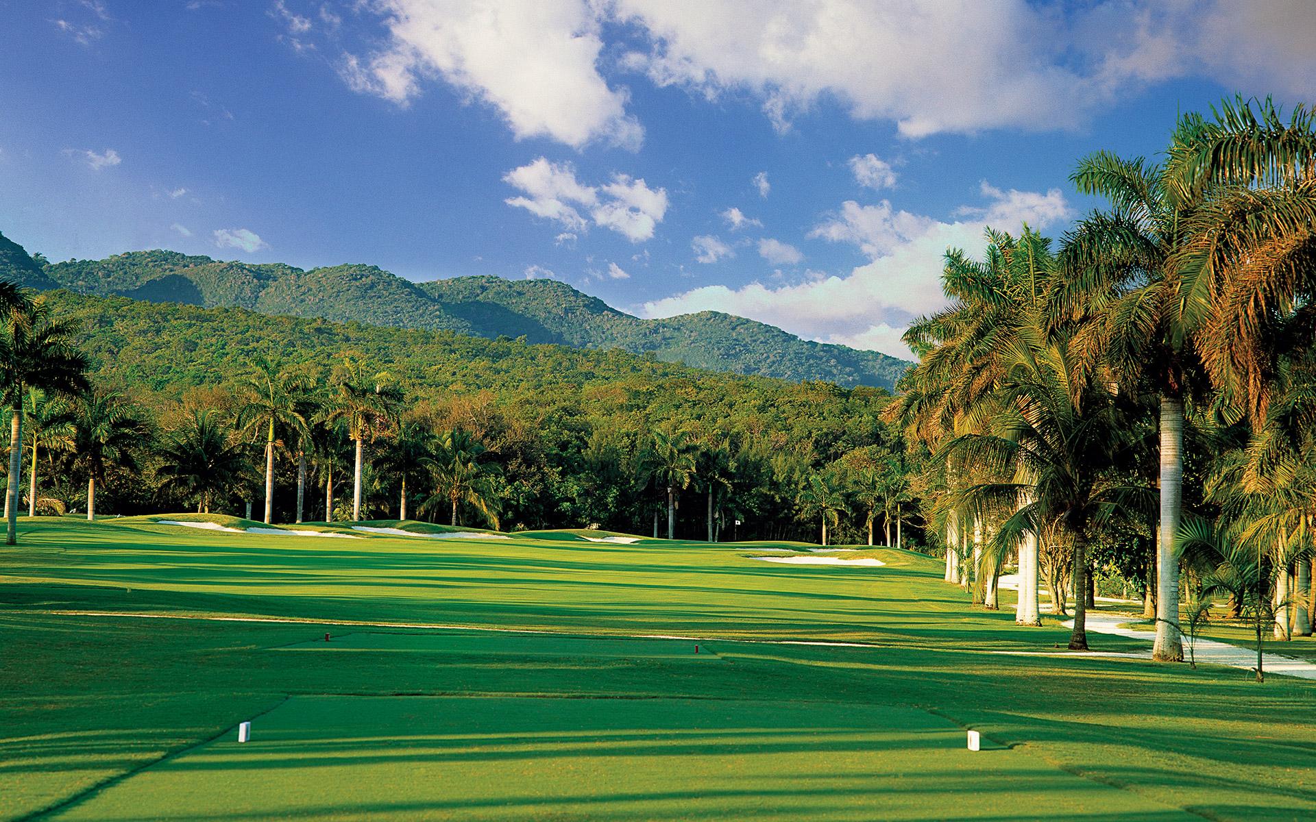 A well maintained fairway nestled with sand bunkers