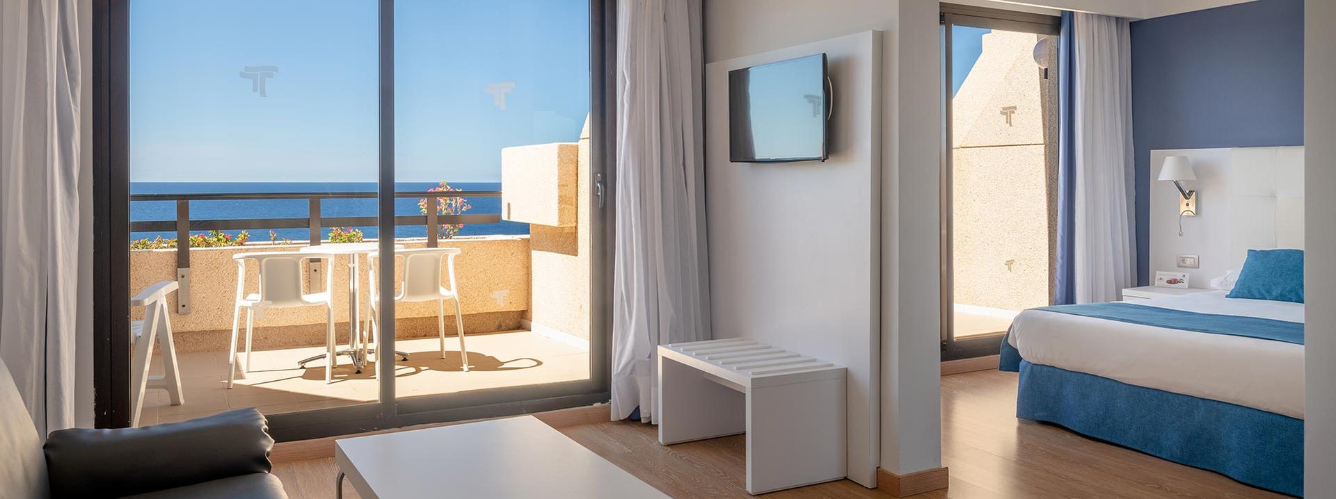 Spacious double bed suite at Alexandre Teguise Playa with a separate bedroom and balcony views