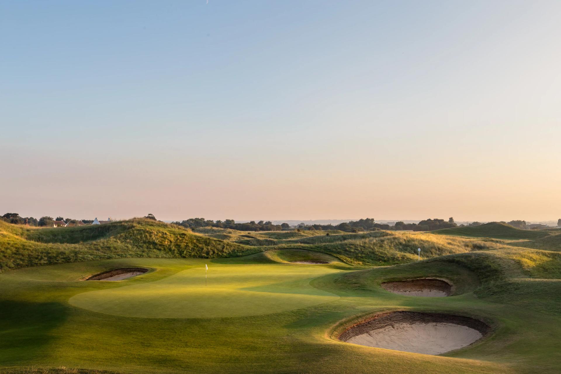 A smooth green next to a sand bunker at Royal St George's Golf Club