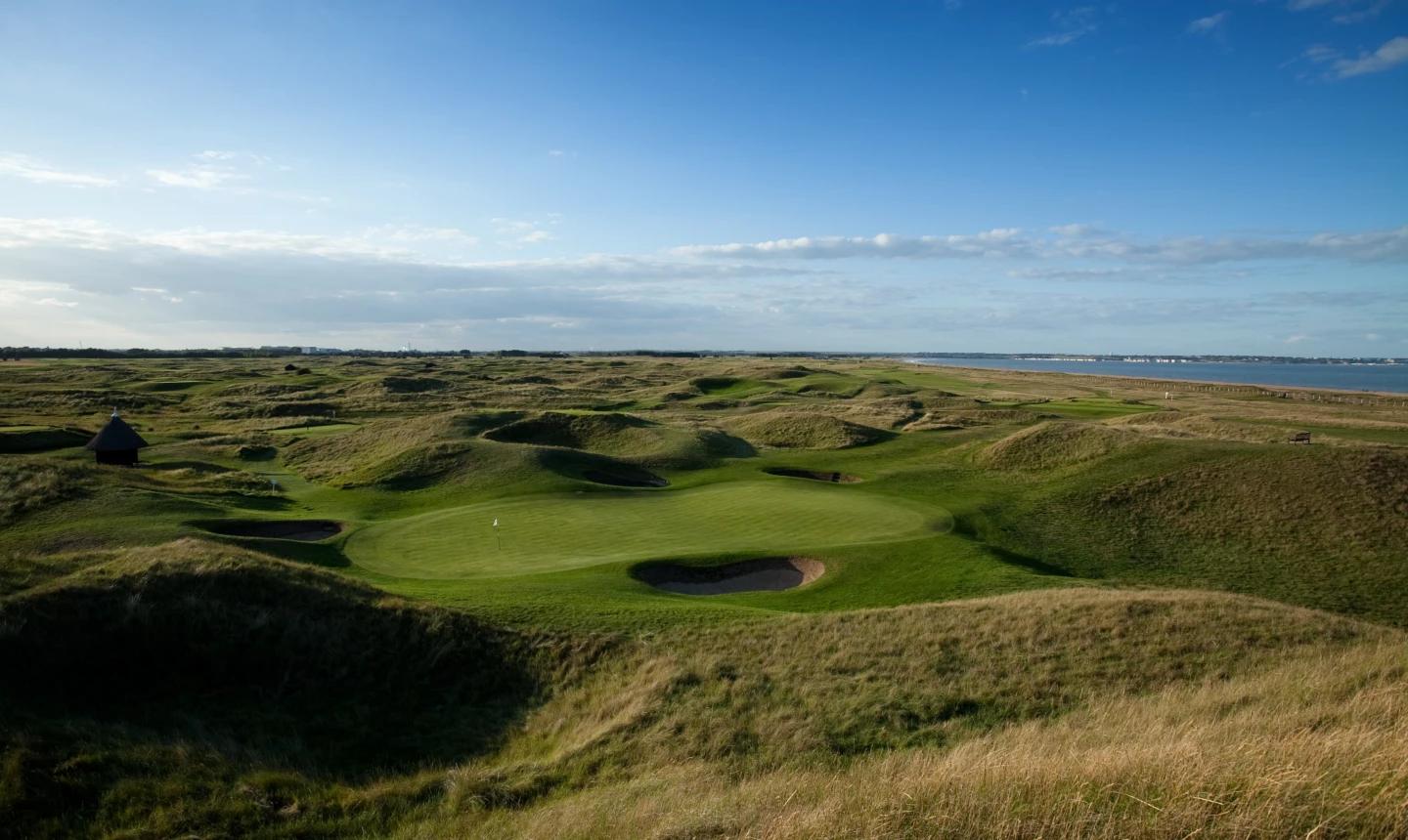 A smooth green surrounded by rolling dunes