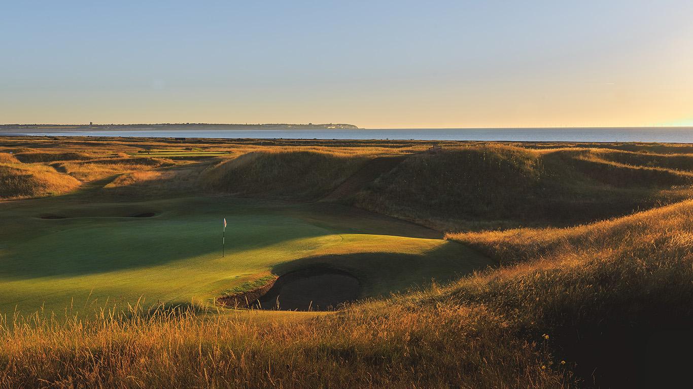 A smooth green next to a deep sand bunker at Royal St George's Golf Club
