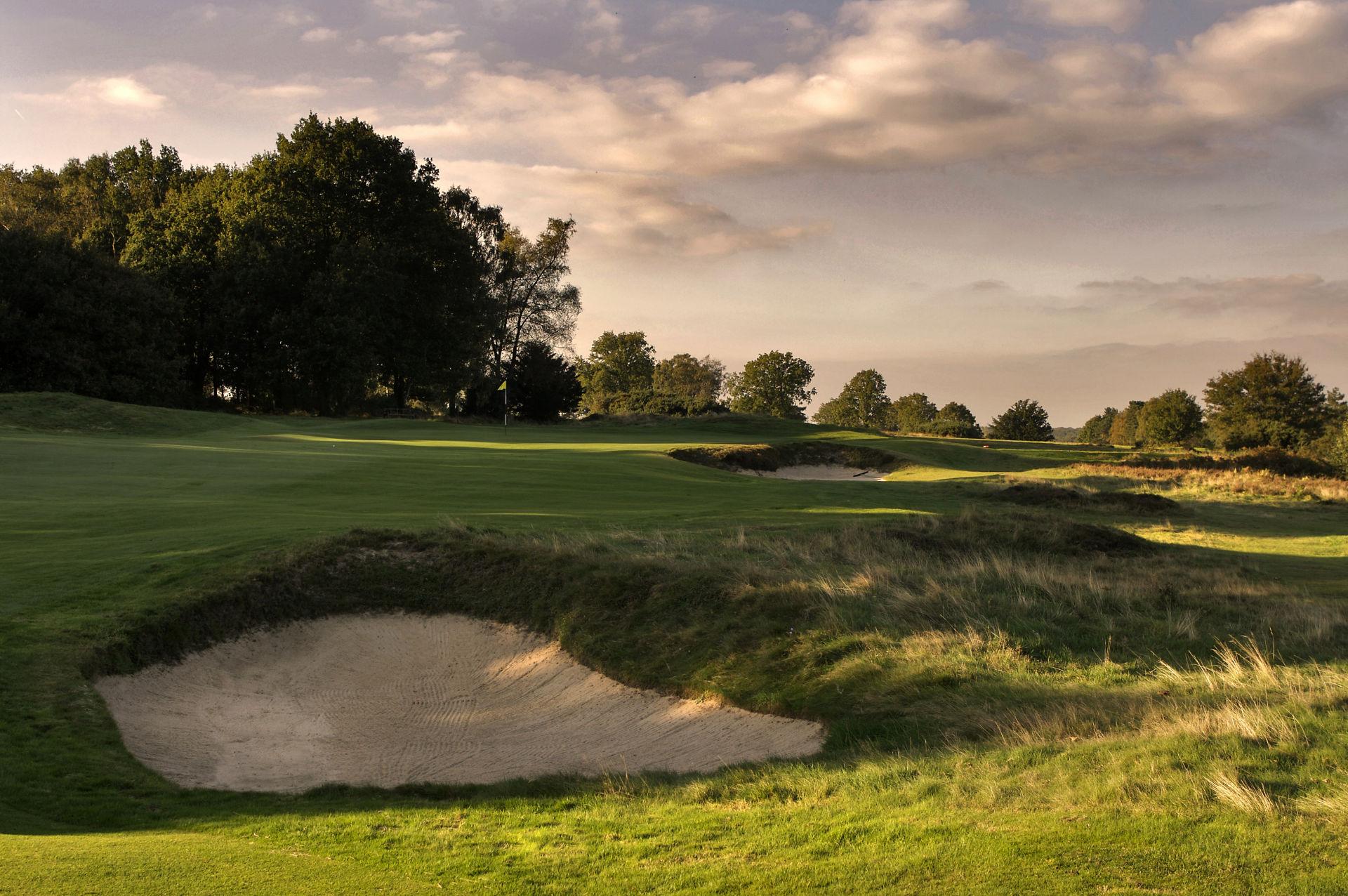 A smooth green next to a sand bunker