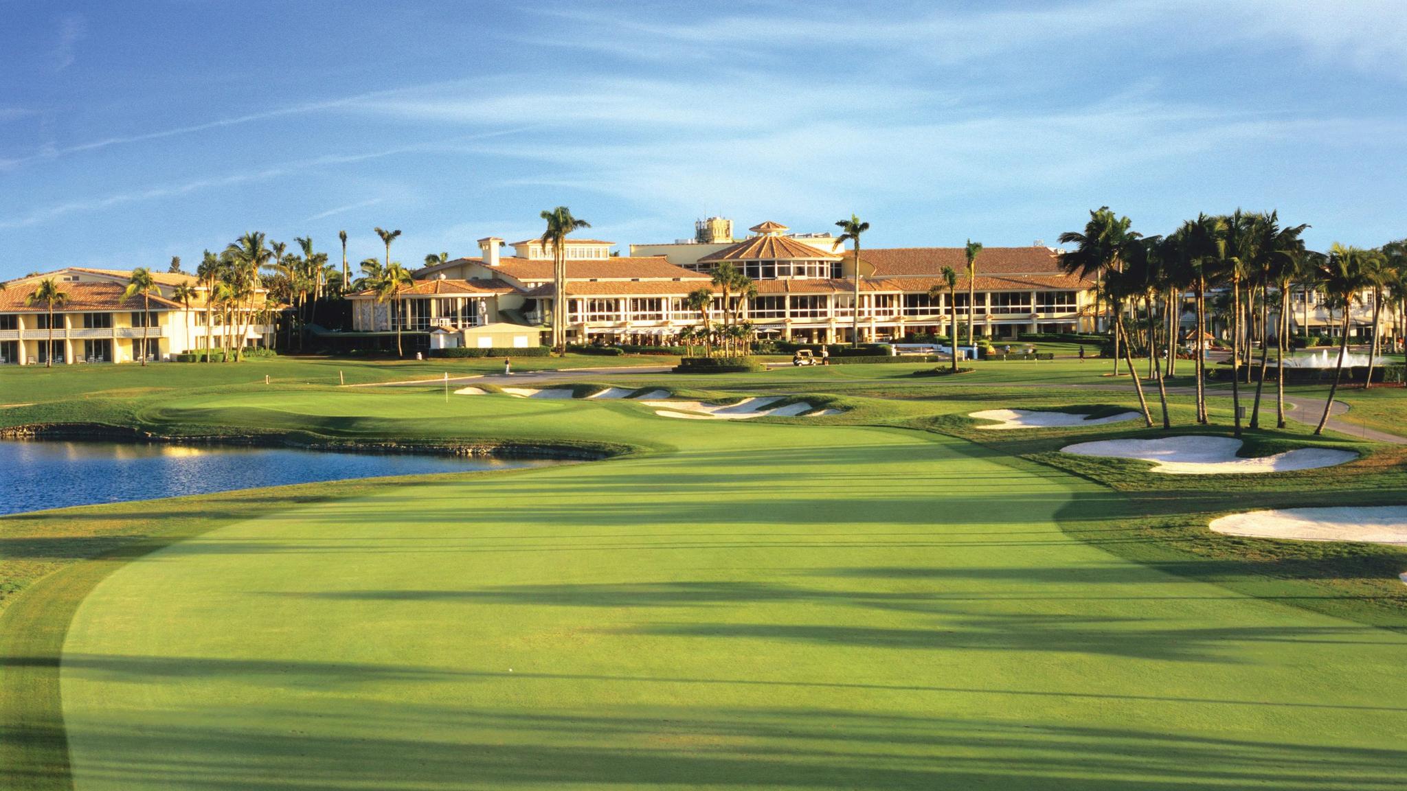 A well maintained fairway nestled with sand bunkers leading towards the clubhouse