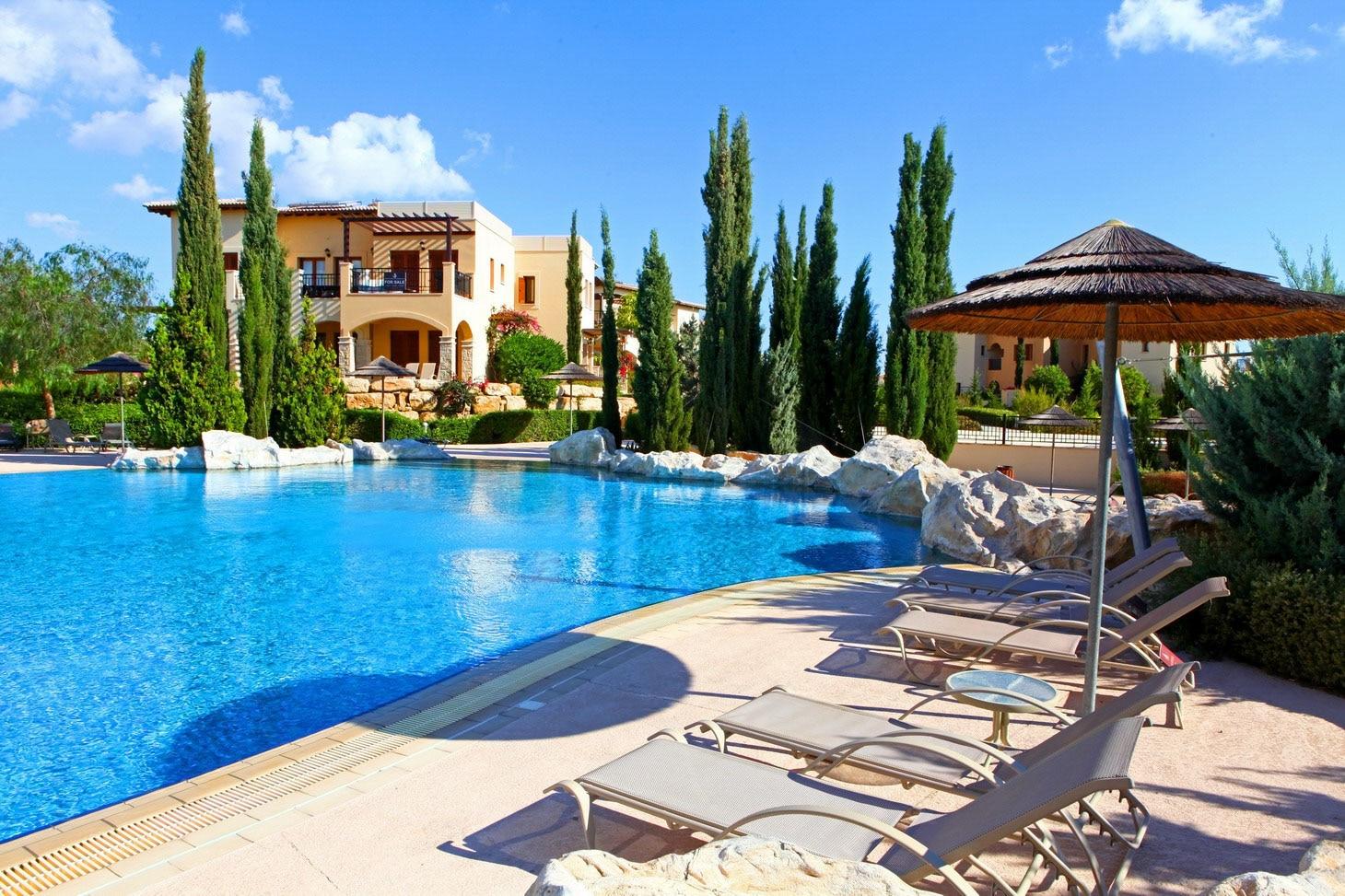 Outdoor swimming pool next to sunbeds at Aphrodite Hills Resort