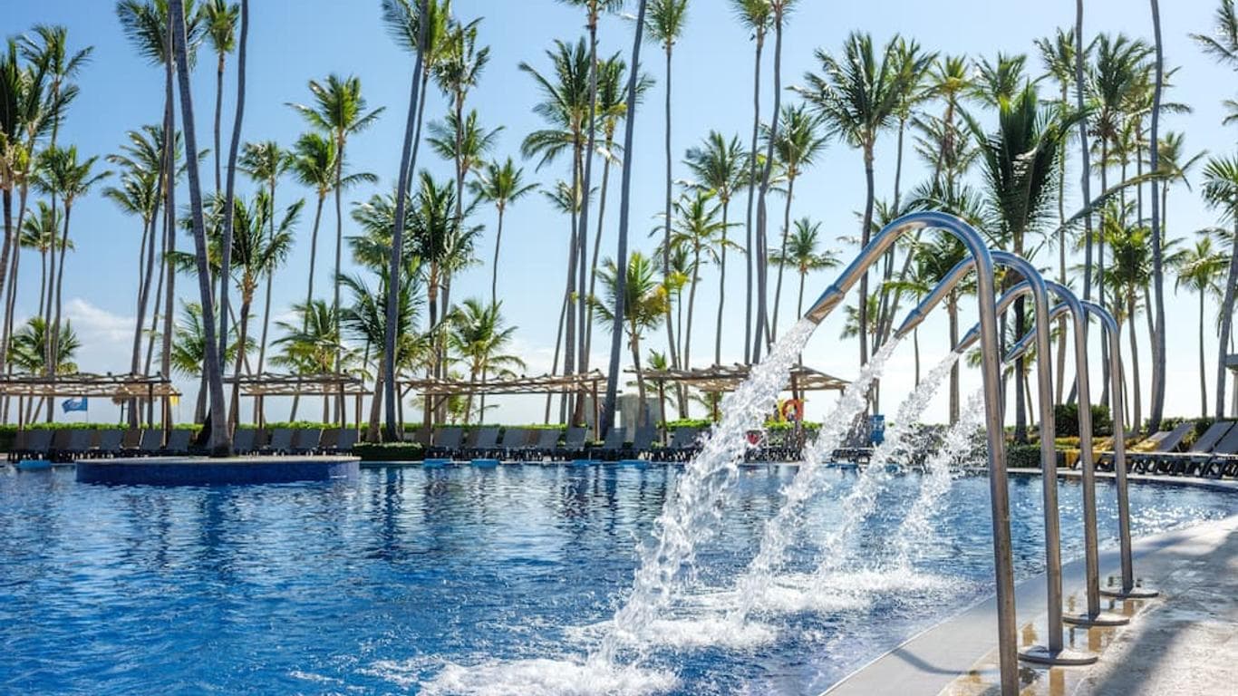 Outdoor swimming pool surrounded by palm trees