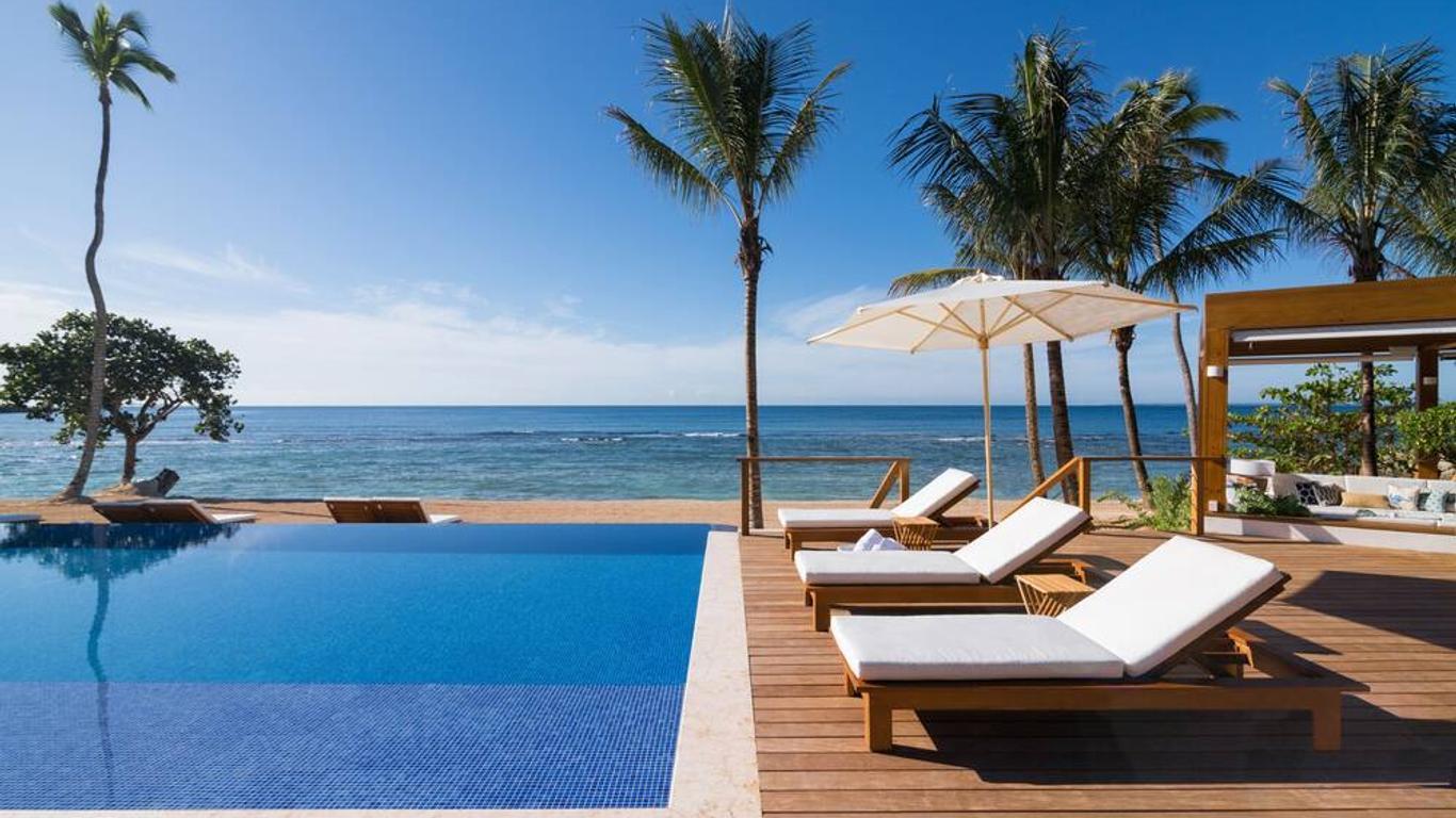 A outdoor swimming pool with sunbeds and ocean views