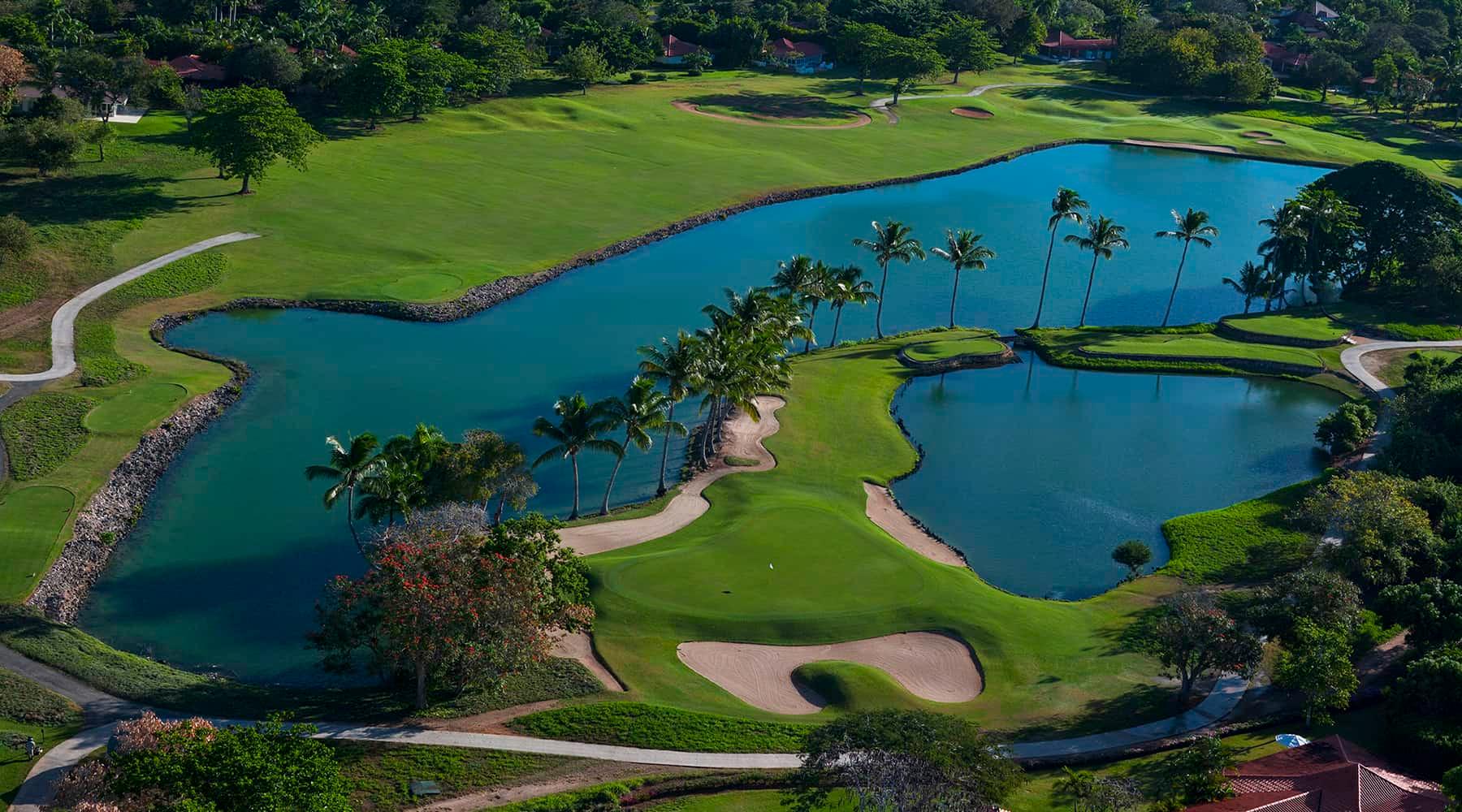 A well maintained fairway running besides a water hazard
