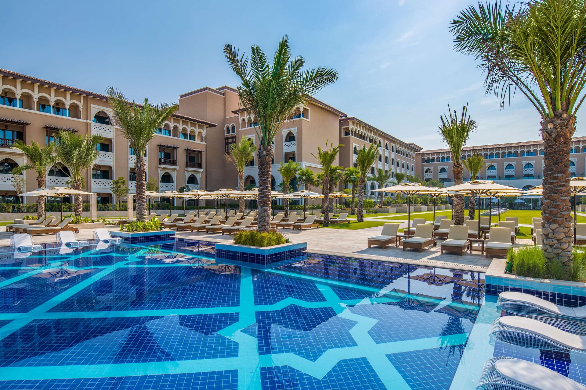 Outdoor swimming pool surrounded by palm trees