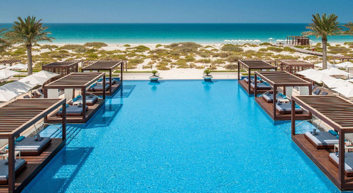 Outdoor swimming pool with ocean views at The St Regis Saadiyat Island Resort