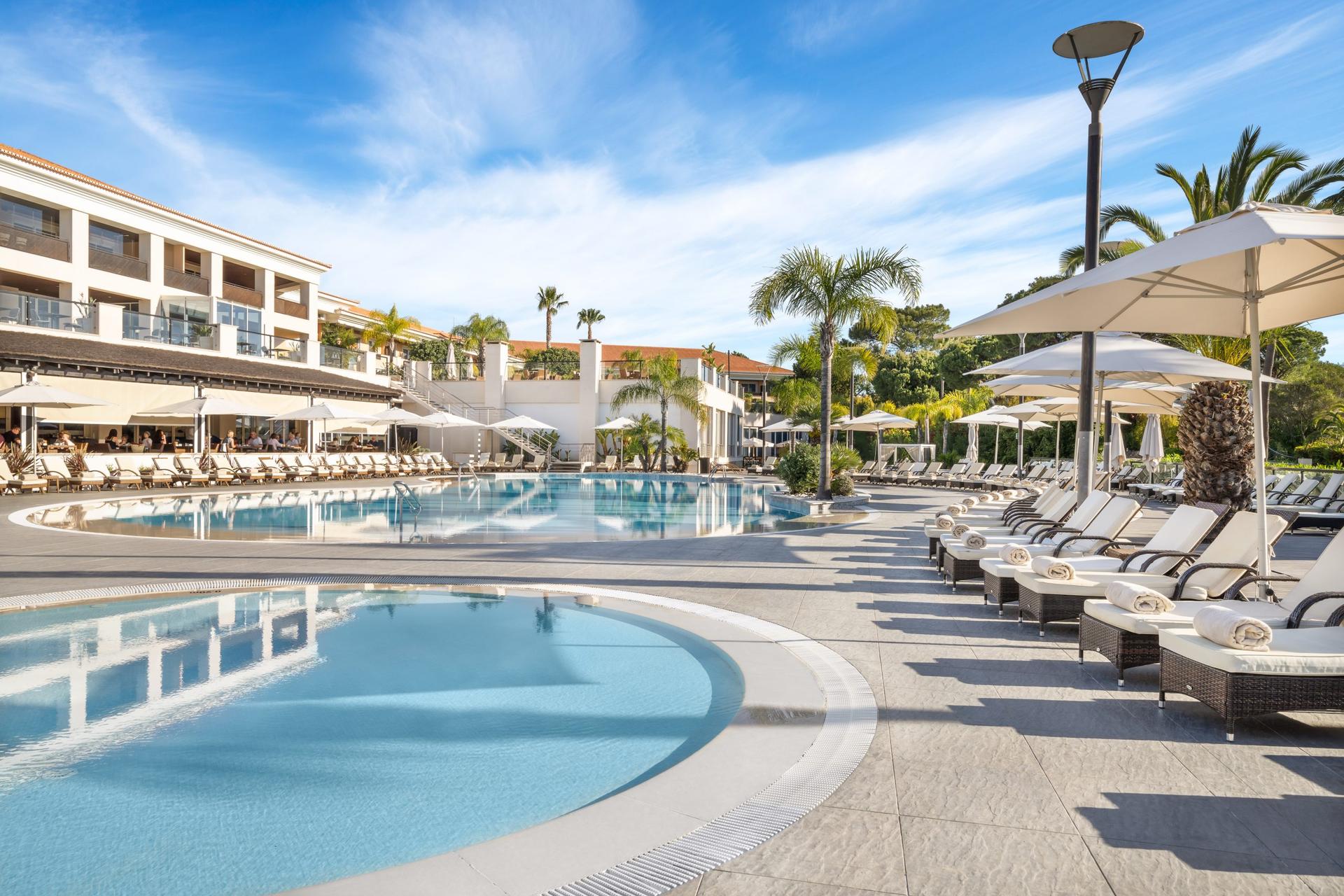 Outdoor swimming pool surrounded by sunbeds