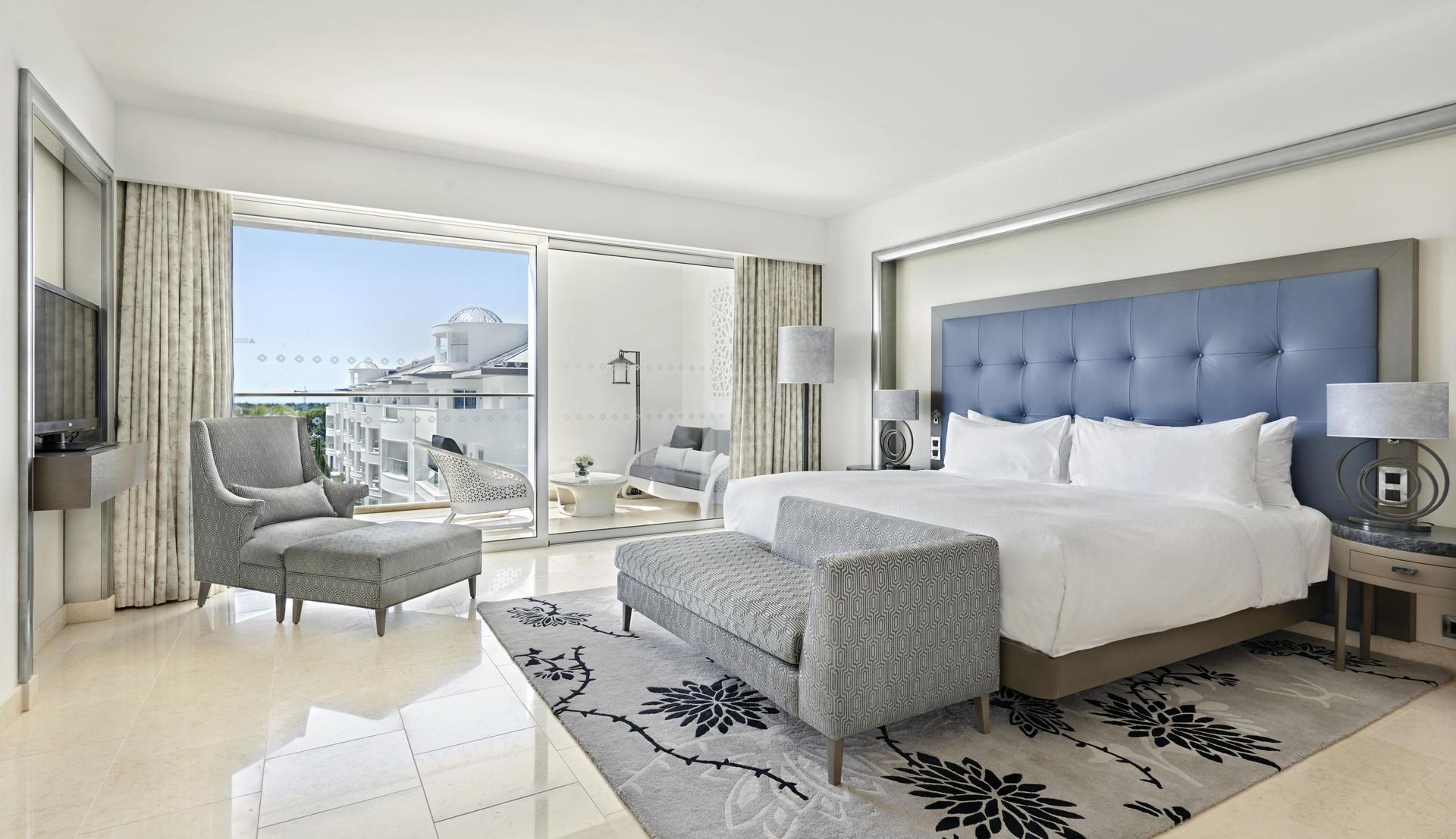 A spacious double bed suite with balcony views at the Conrad Algarve hotel