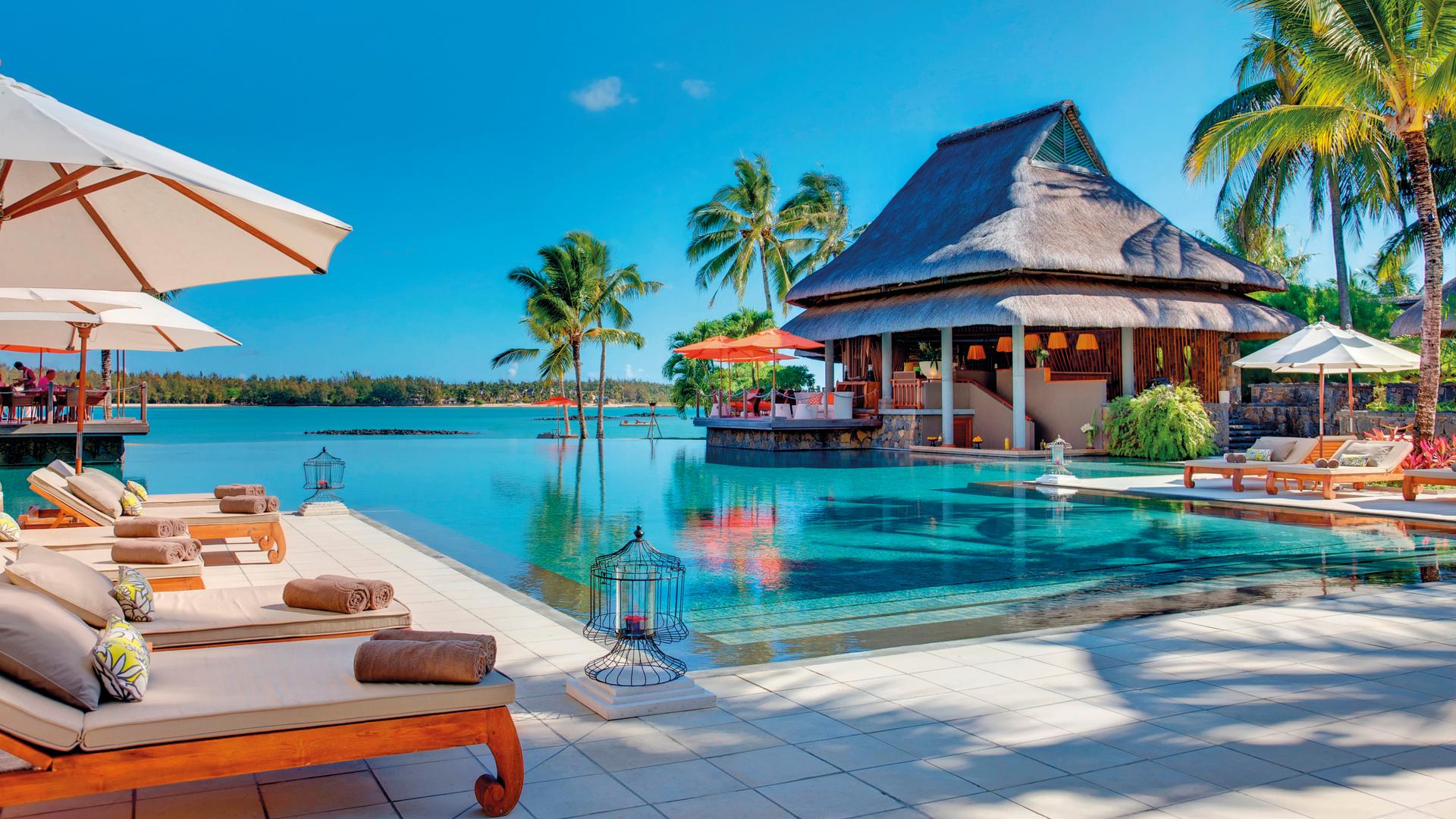 Panoramic view of outdoor swimming pool surrounded by sun beds