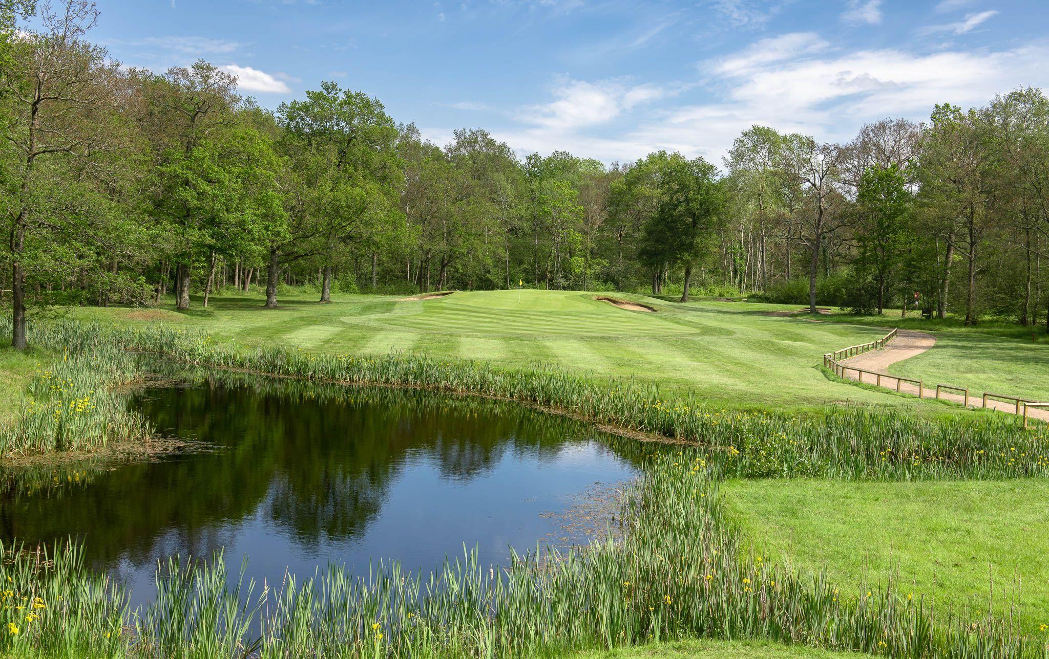 A well maintained fairway next to a water hazard