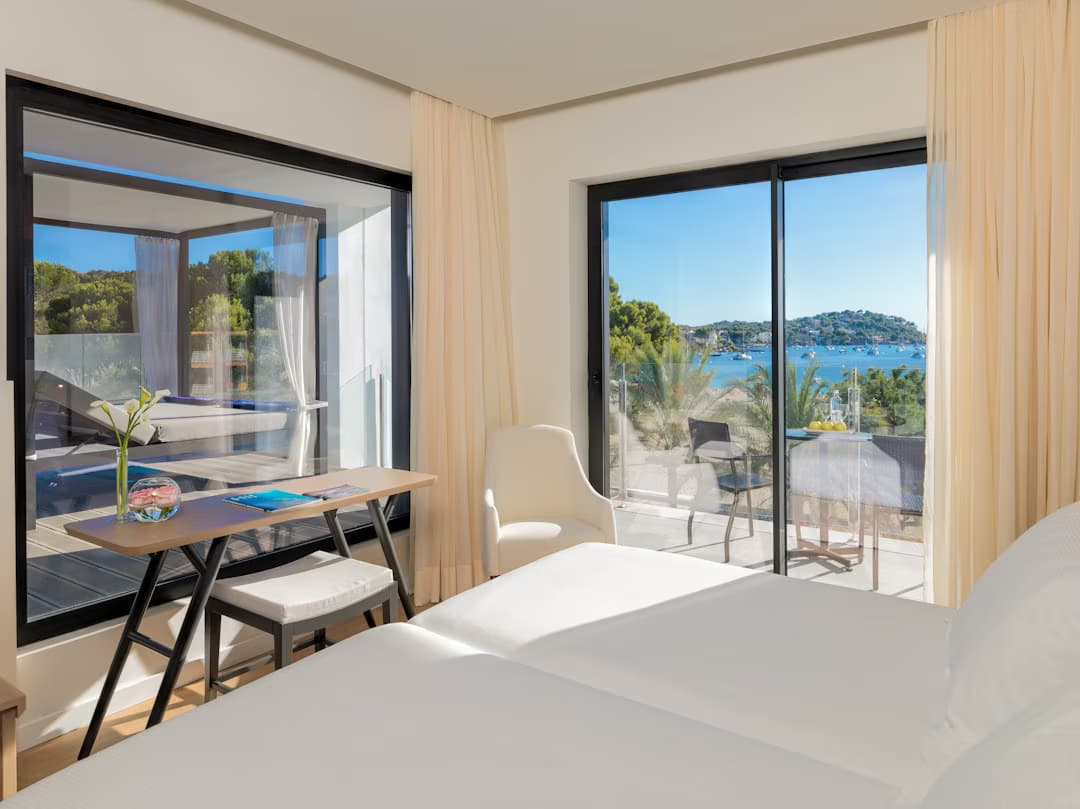 Double bed room with balcony views of the ocean and a sunbed on the balcony
