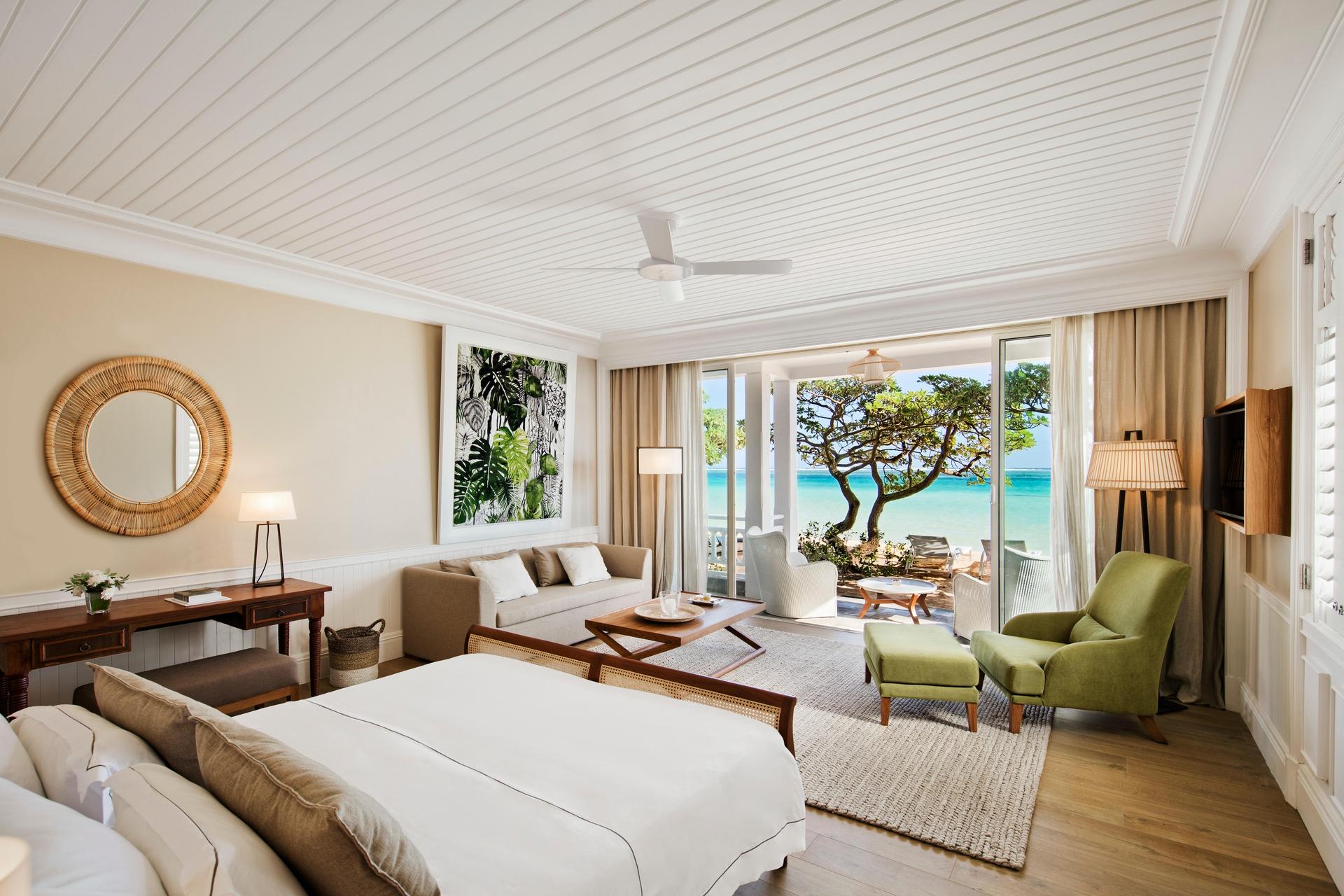 Luxurious double bed room at Heritage Le Telfair with a patio space leading out to the beach
